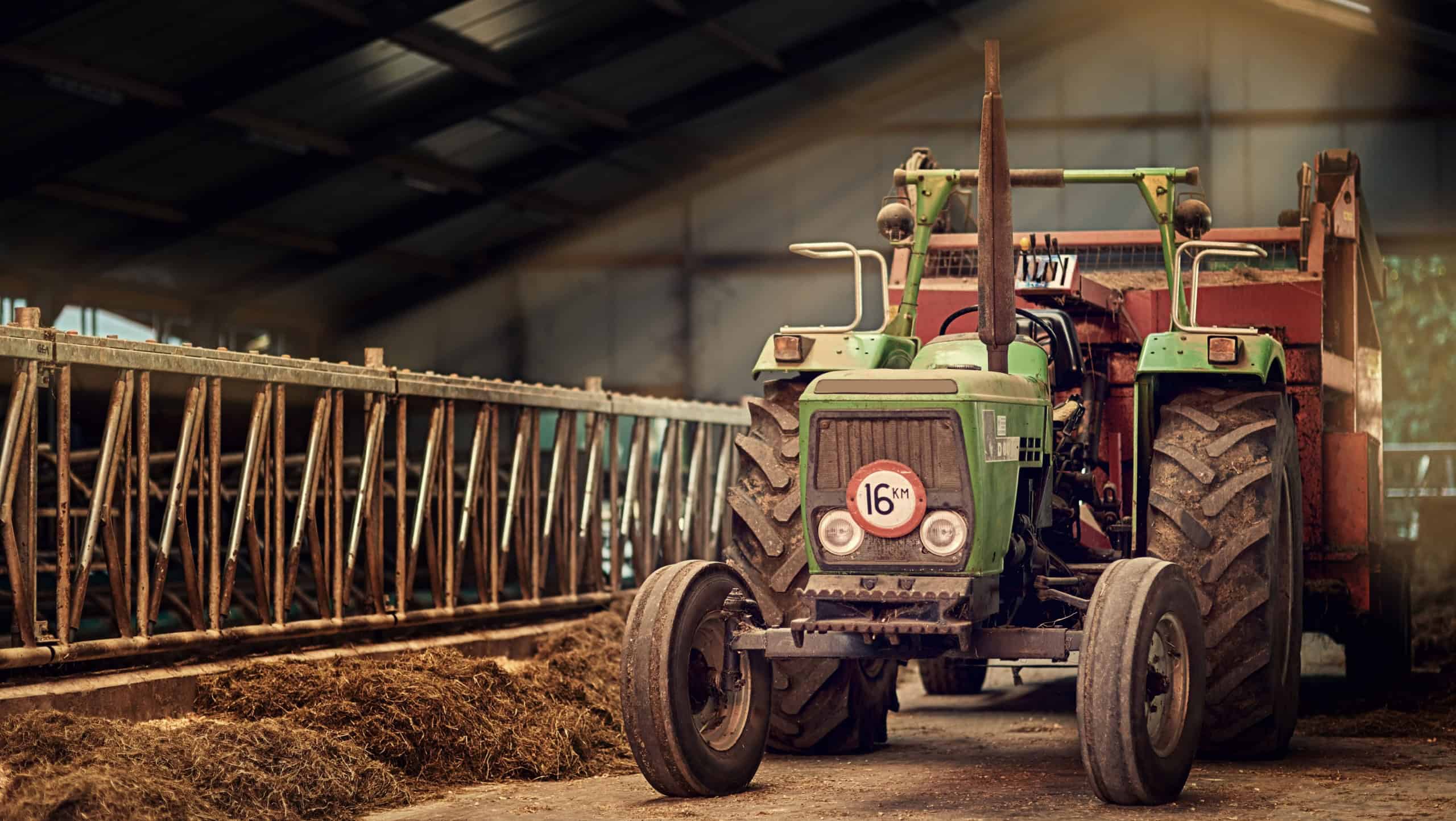 Old, machine and tractor in barn on farm with dirt, rust and dust in storage warehouse on land. Vintage, retro and motor with plow truck in factory shed or tools for farming production or agriculture