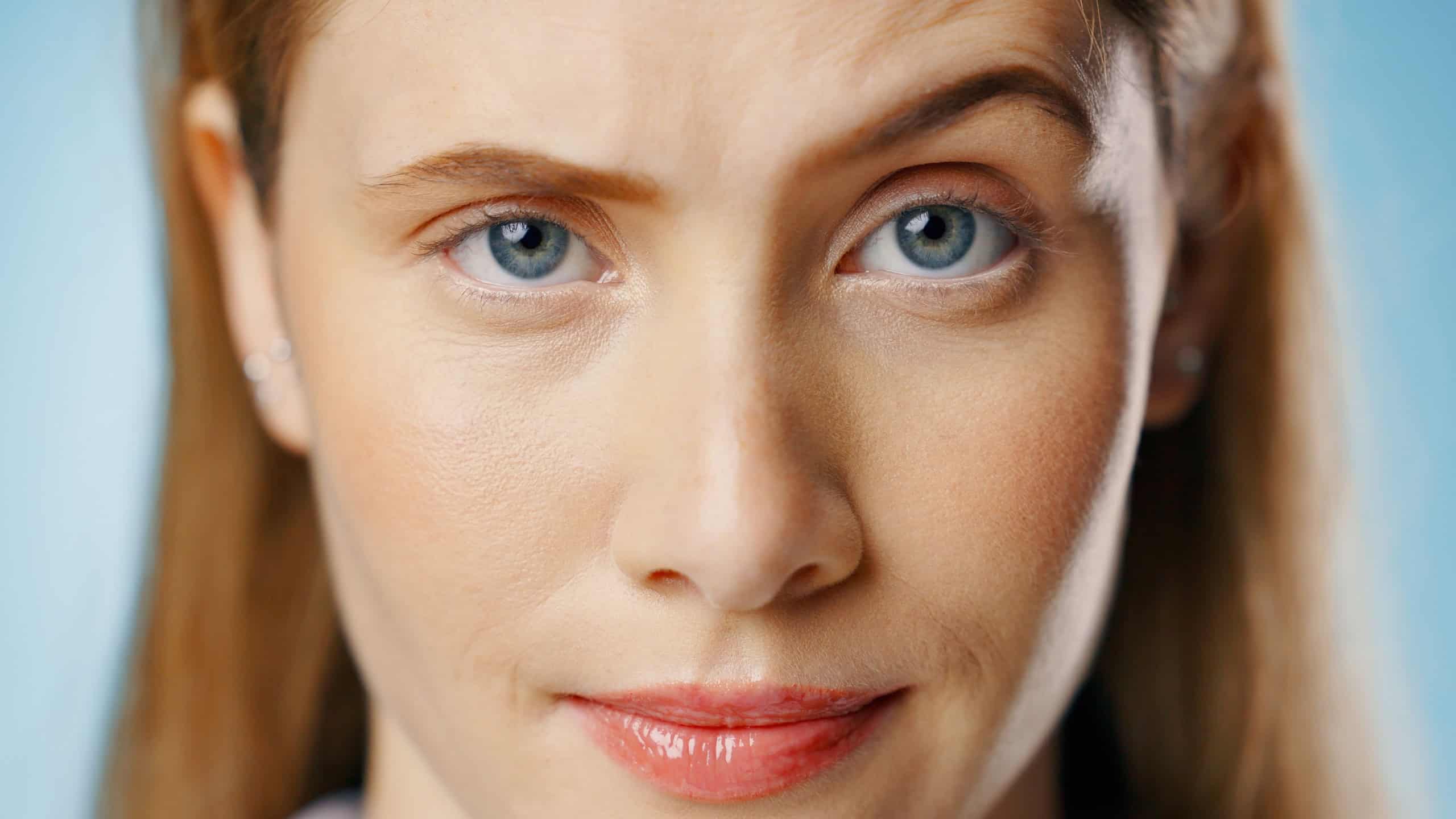 Woman with blue eyes and subtle smile, looking directly at the camera.