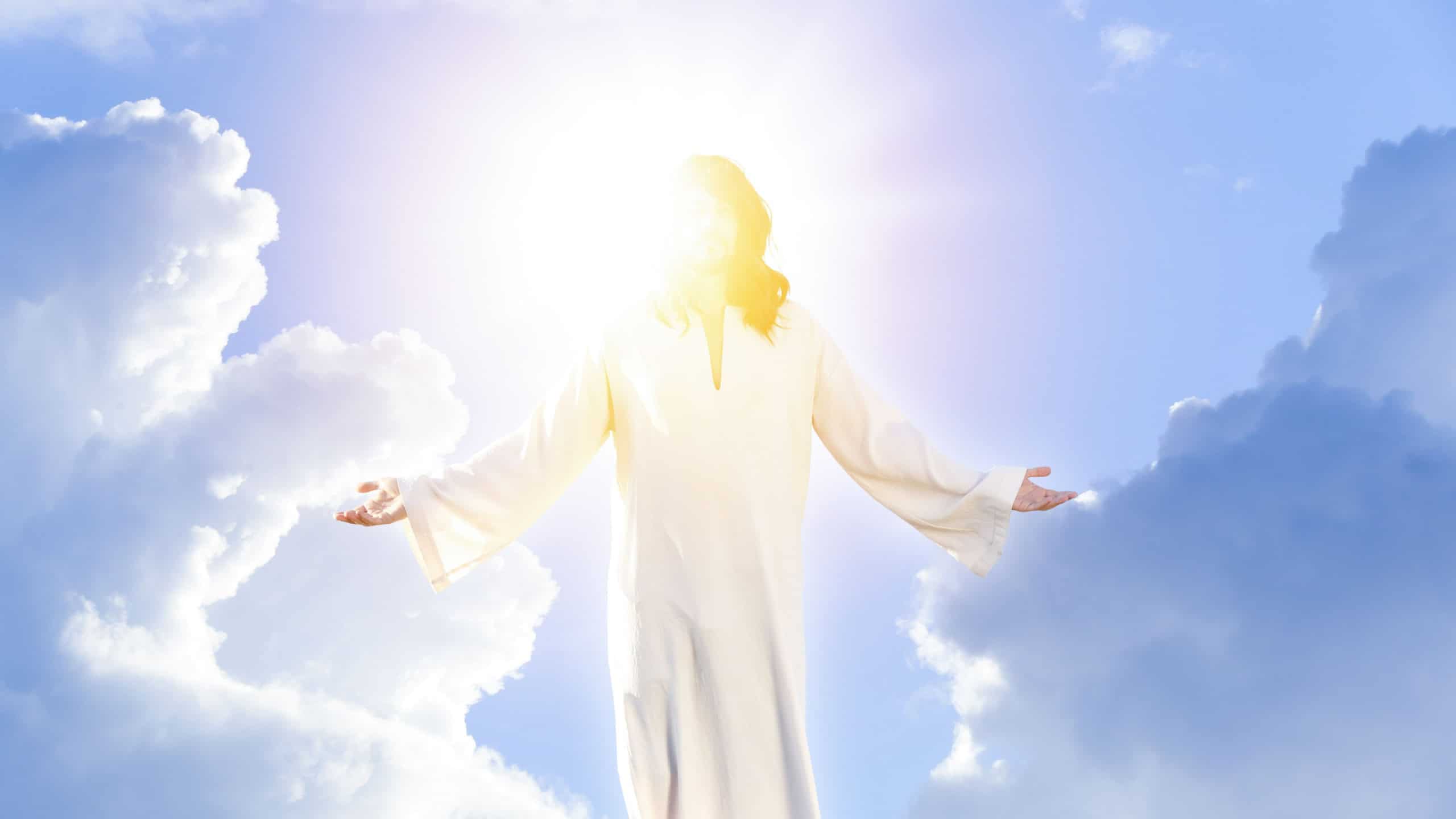 Jesus Christ in sunlight among clouds in sky