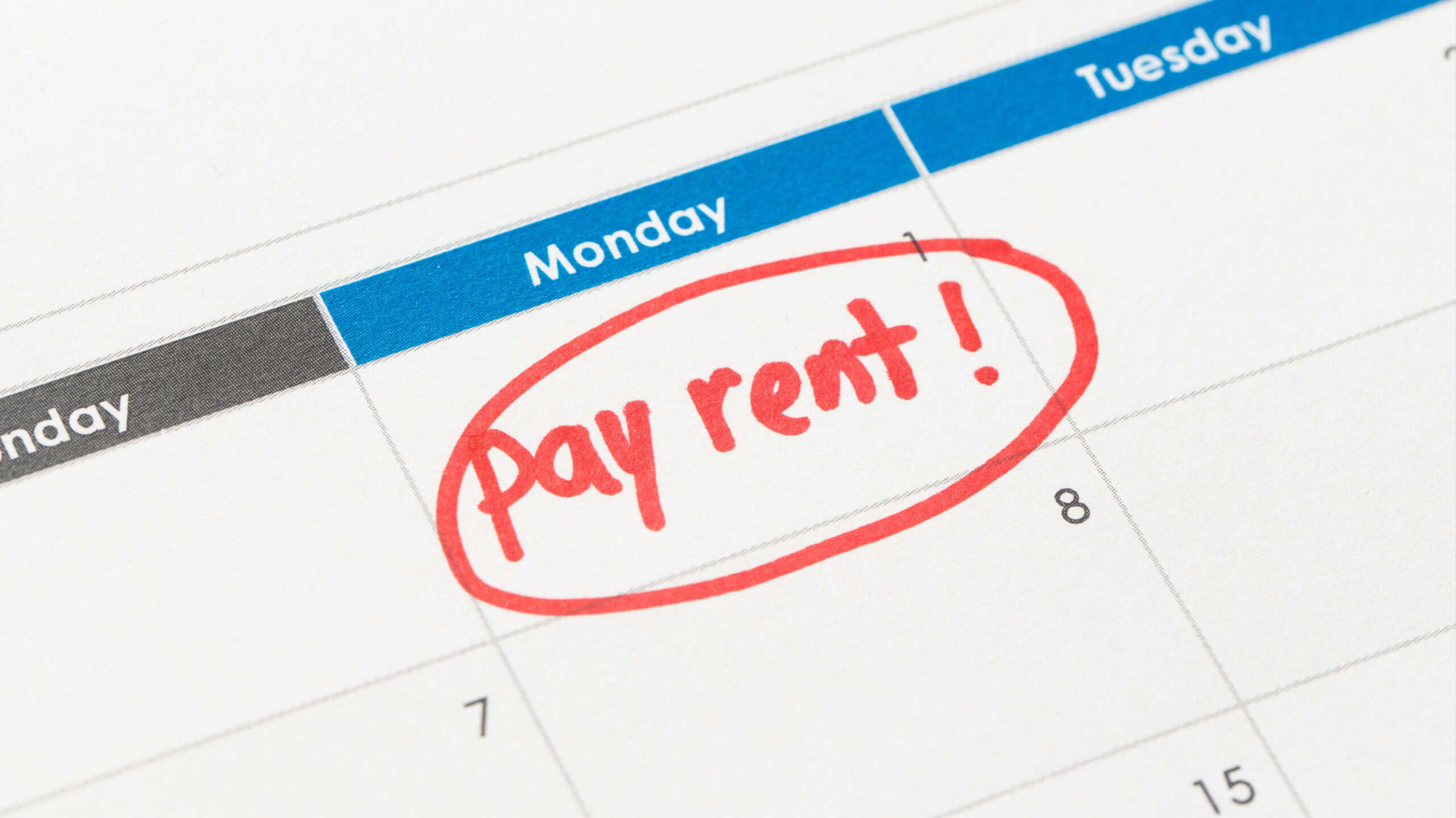 Calendar with the words pay rent written in red ink and circled, emphasizing a due date reminder. The image highlights the importance of rent payment deadlines.
