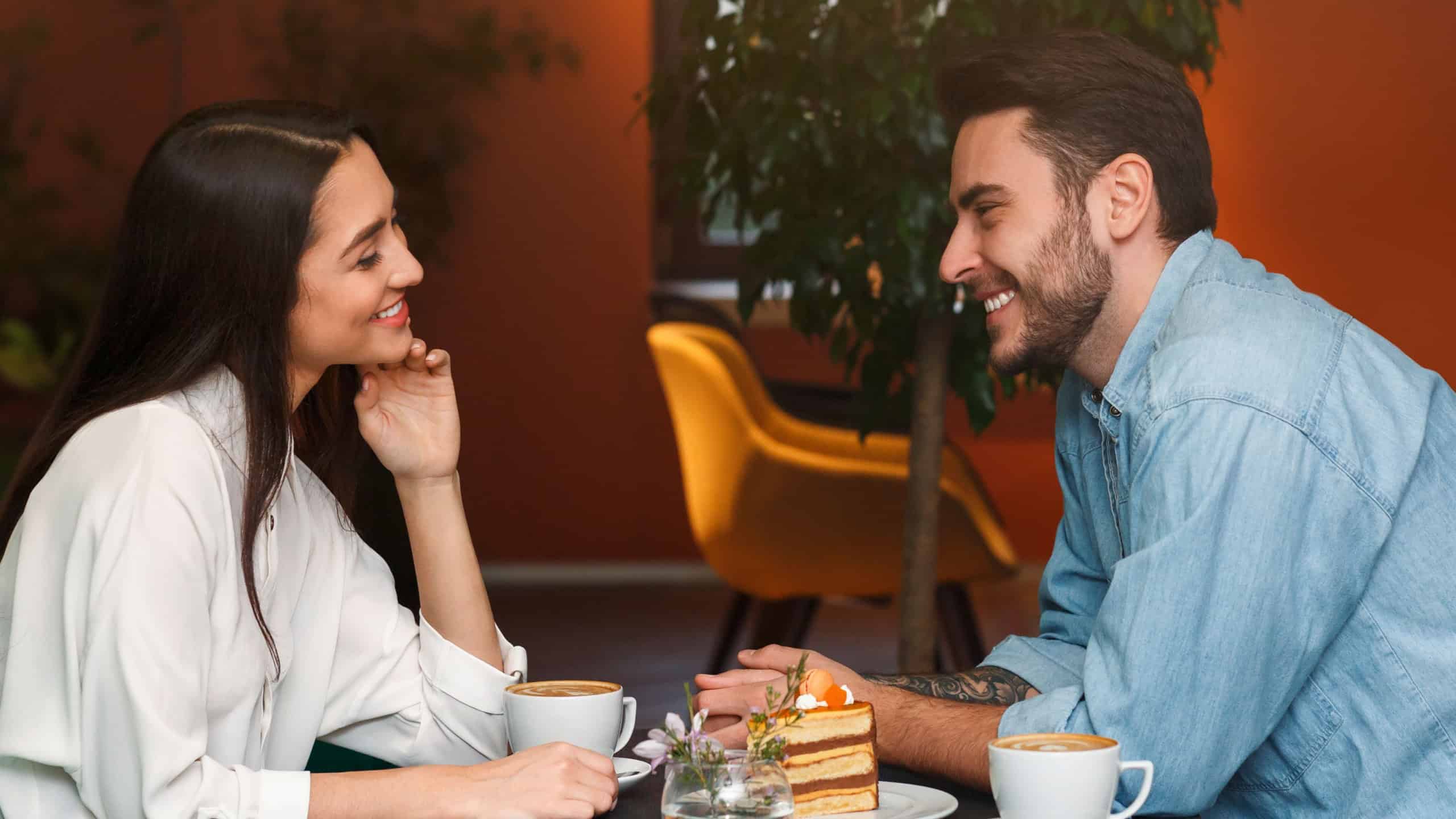 Romantic Date. Millennial Couple In Love Talking And Smiling Each Other Sitting In Coffee Shop Cafe.