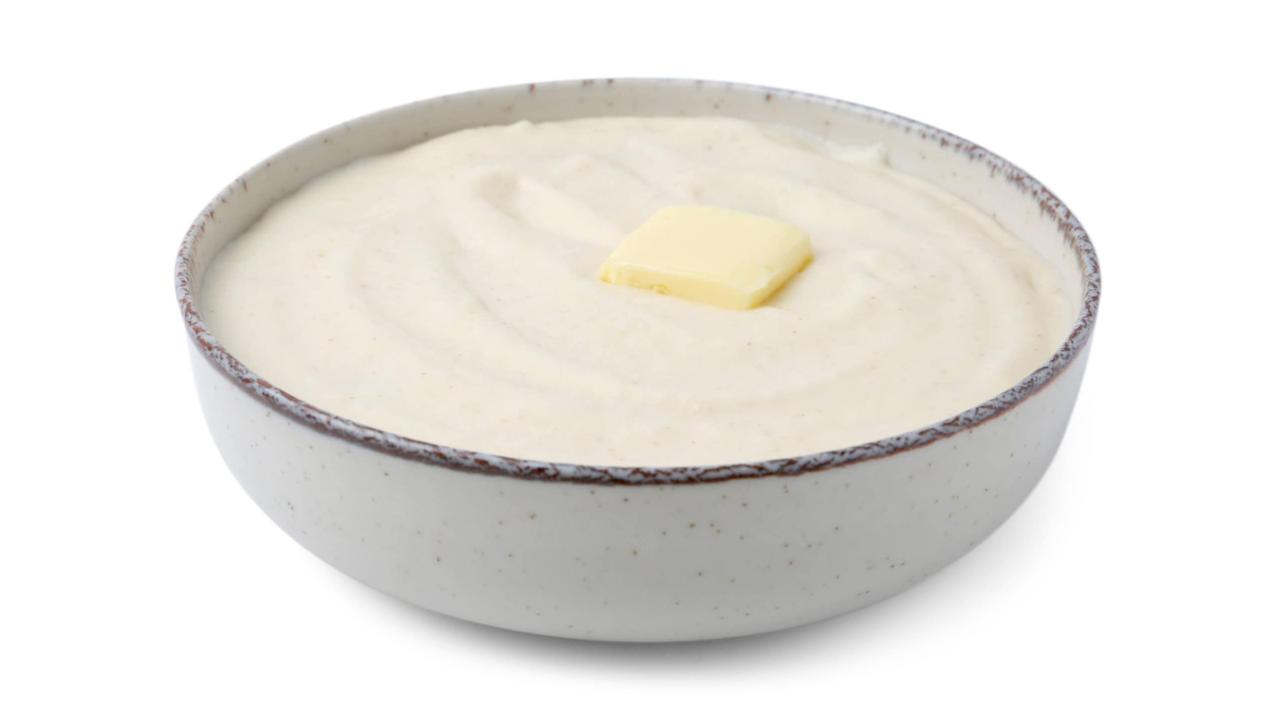 Tasty cooked semolina porridge with butter isolated on white