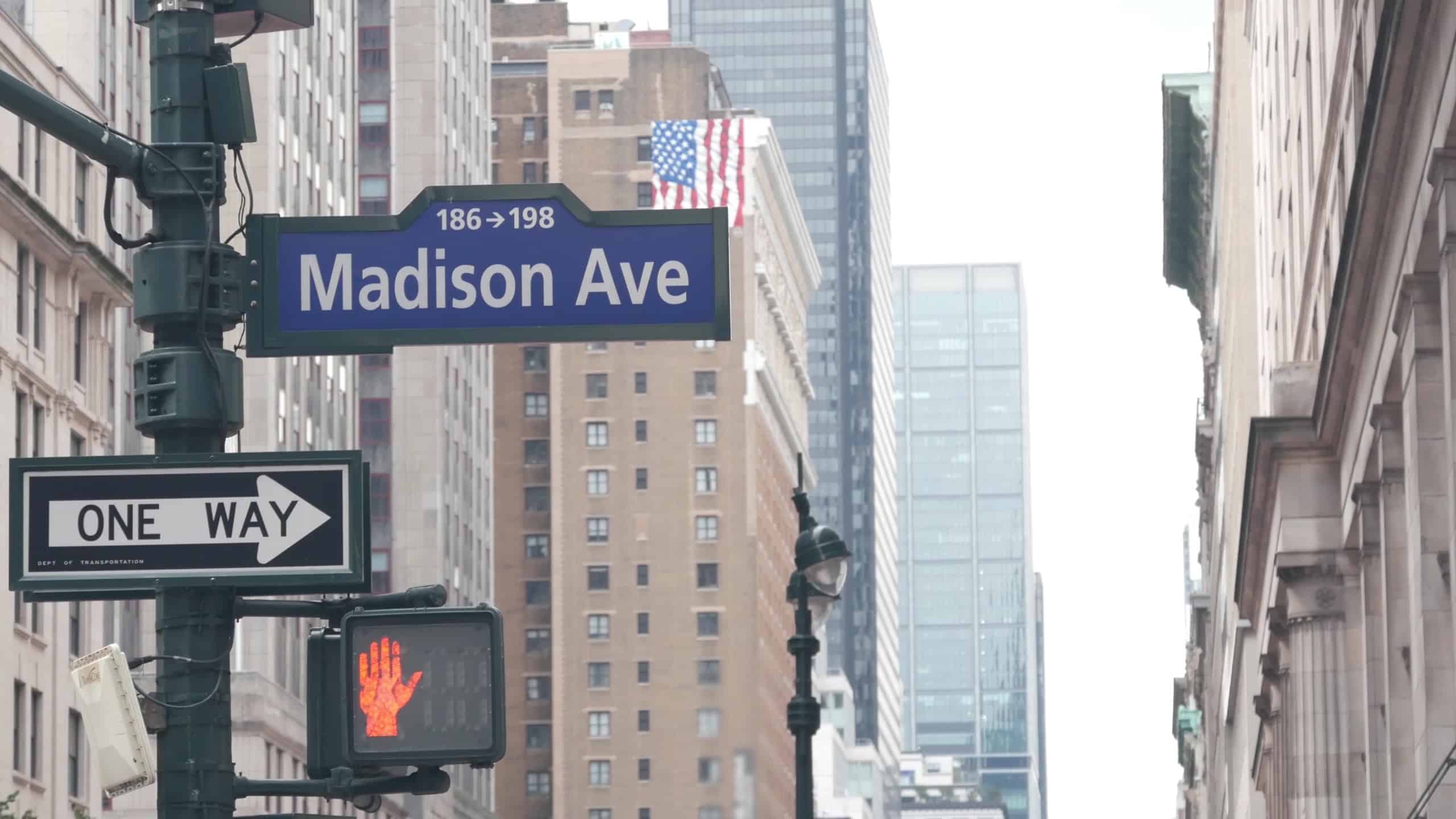New York City crossroad, Manhattan corner, Madison avenue, street intersection road sign. Midtown district highrise architecture, United States. One way arrow roadsign, skyscrapers and traffic light.