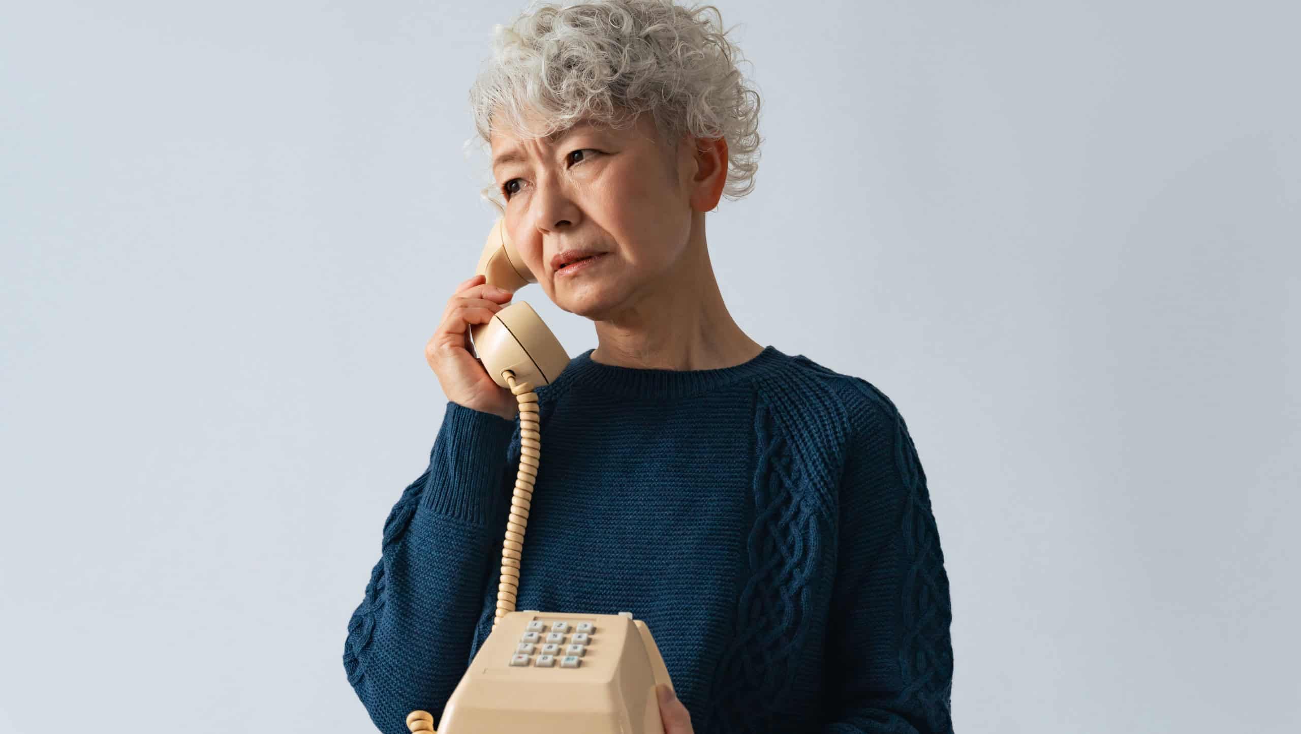 Senior woman with suspicious expression while on the phone