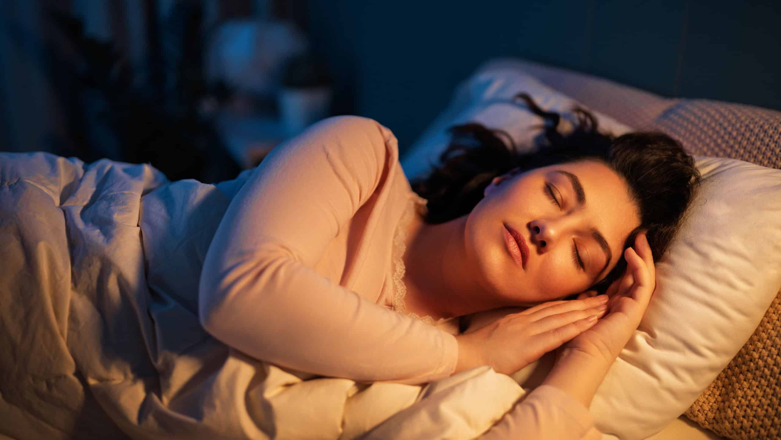 Woman is sleeping peacefully in her bedroom at night.