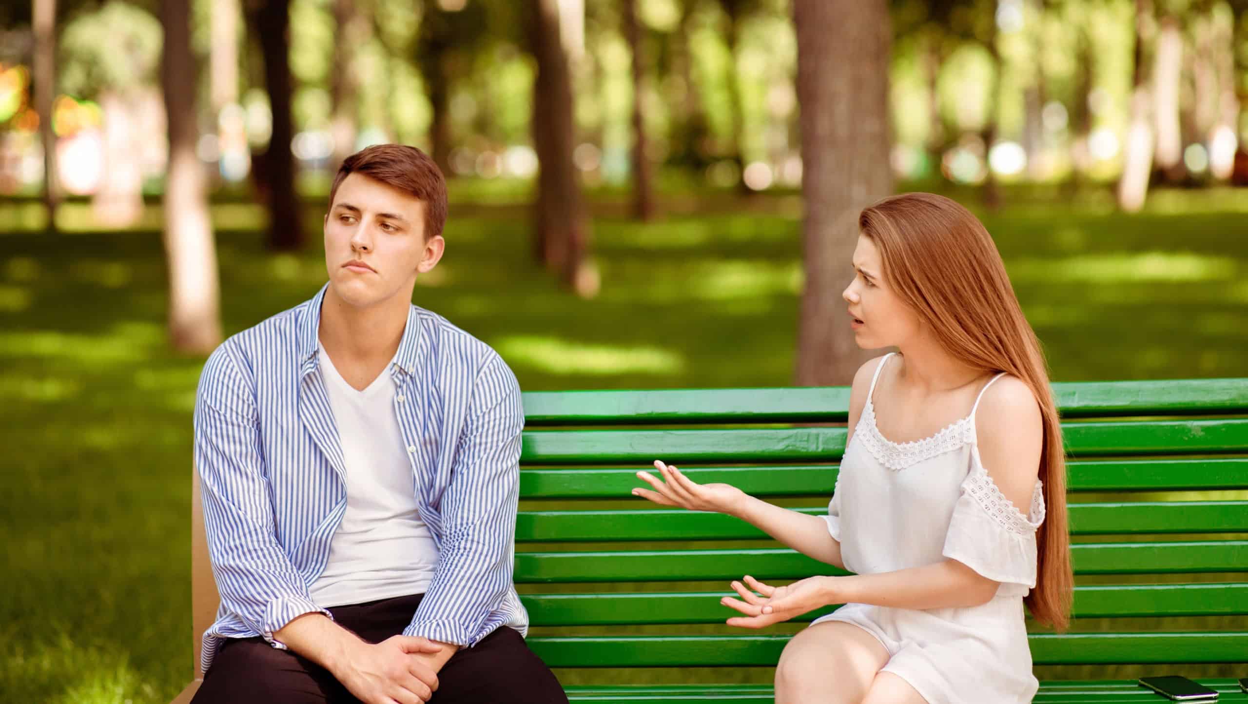Relationship problems. Millennial couple having argument on bench at city park