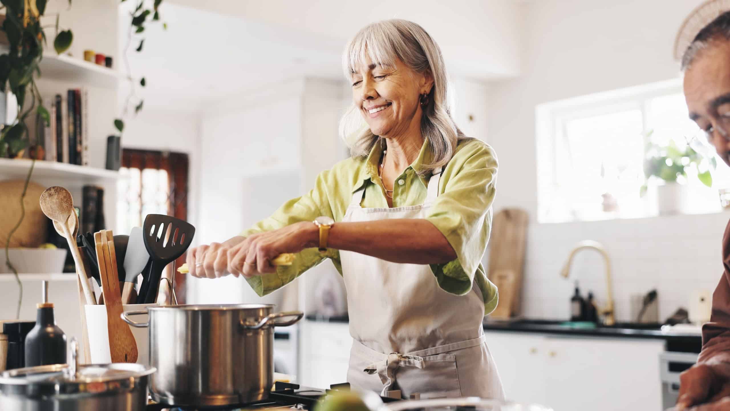 Pasta, cooking and mature couple in kitchen in home with Italian dinner, meal or dish. Happy, pot and man with woman for preparing supper with health, wellness and nutrition in house together