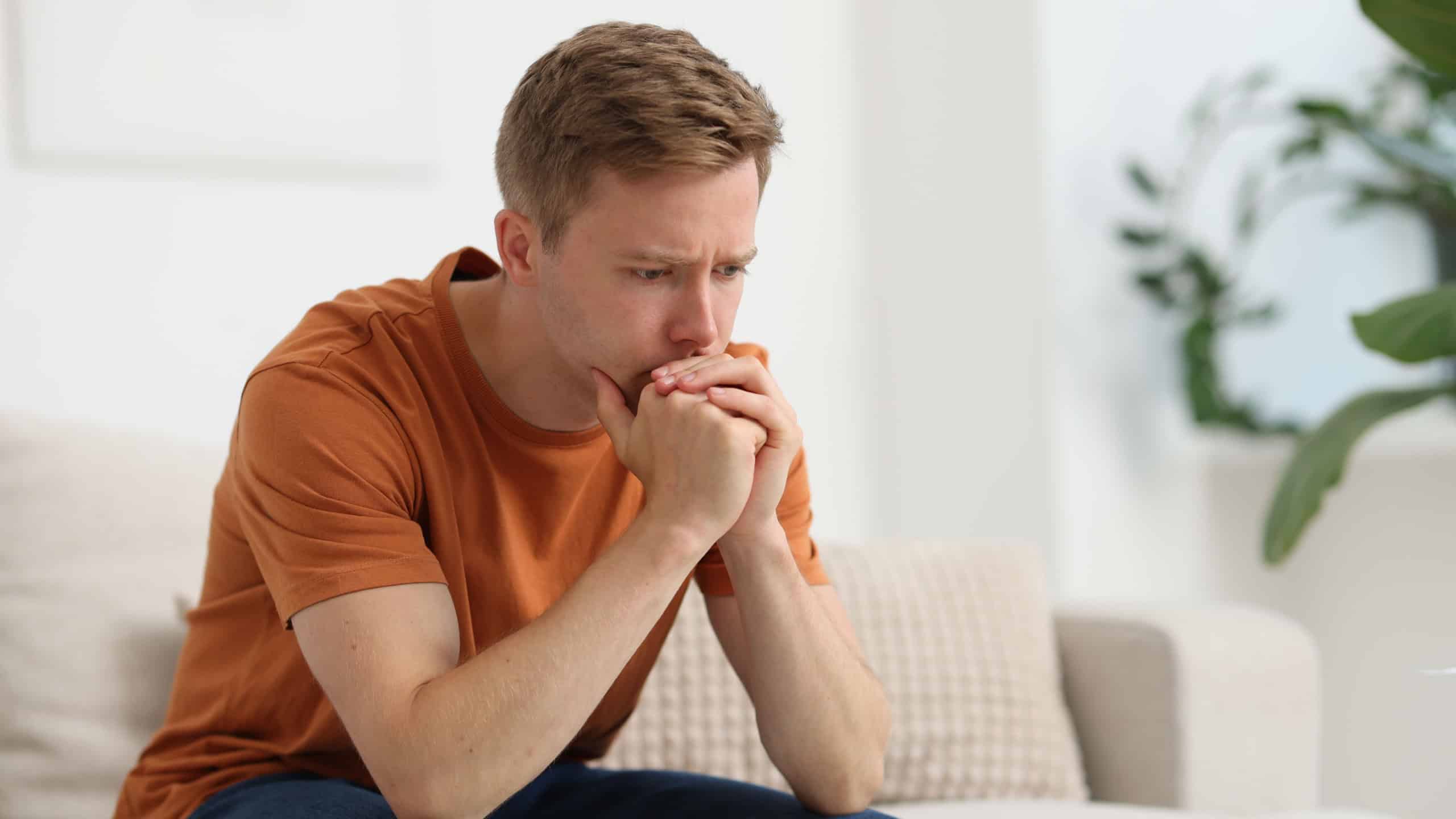 Sad thoughtful man on sofa at home