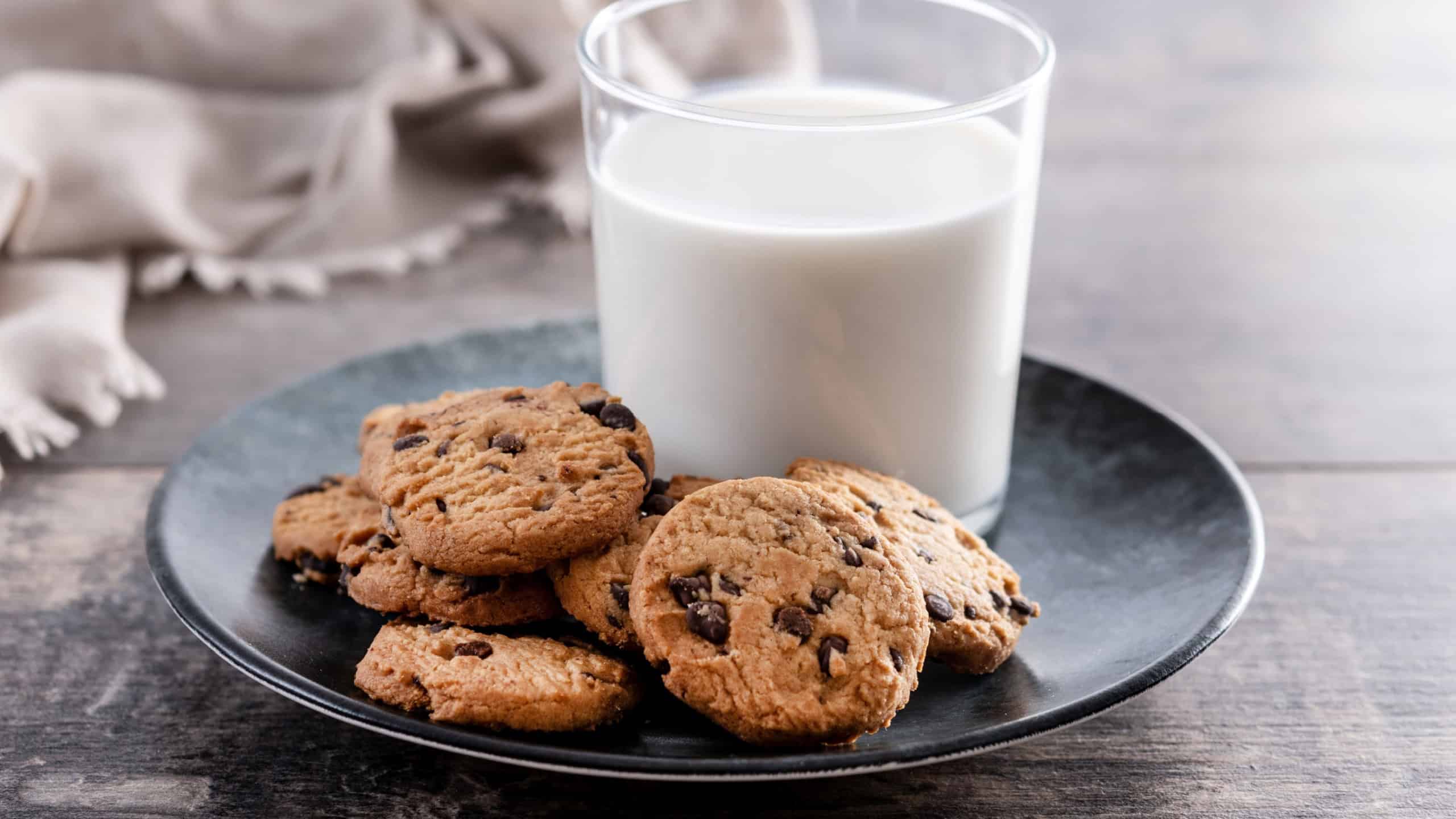 Chocolate chip cookies and milk for breakfast on rustic wooden table
