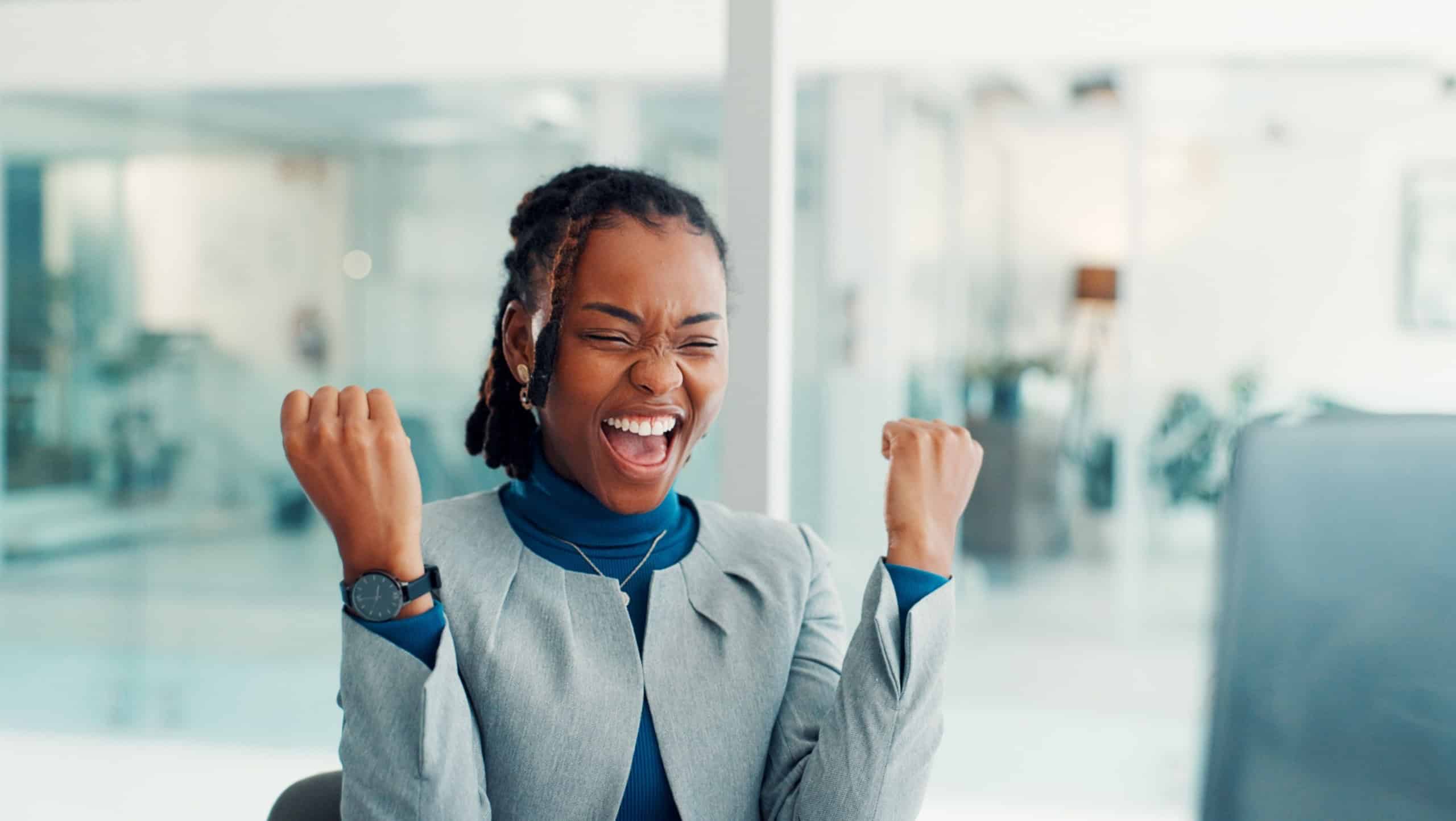 Business, woman and celebration with computer in office for article success, trending story and reward. Journalist, black person and tech with victory fist for blog recognition and career achievement