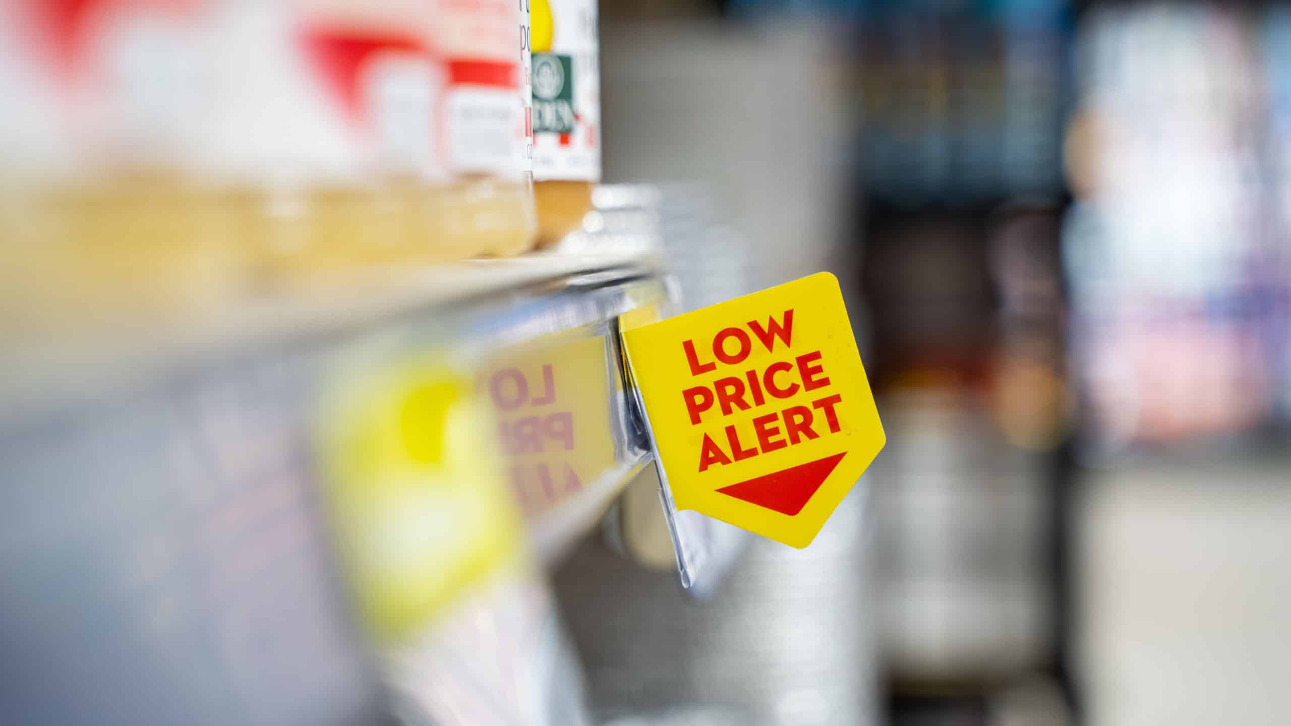 Close up view of low price alert sign on supermarket shelf.