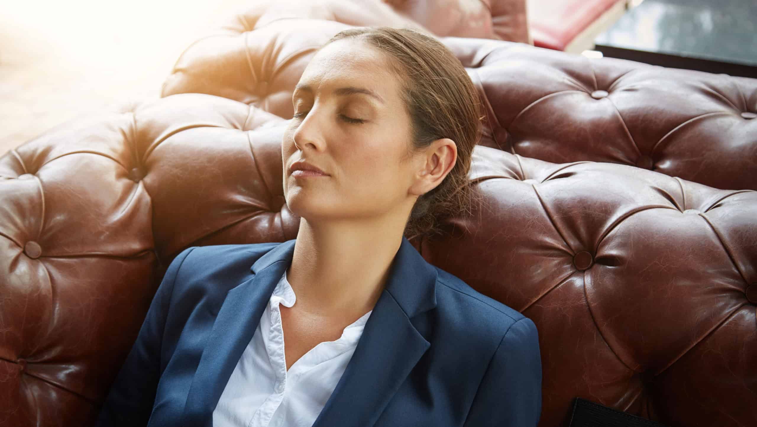 Woman, business and sofa in office for sleeping, overworking case and fatigue in law firm. Tired, lawyer and relax on couch in agency with peace, exhausted and burnout with rest for mental health