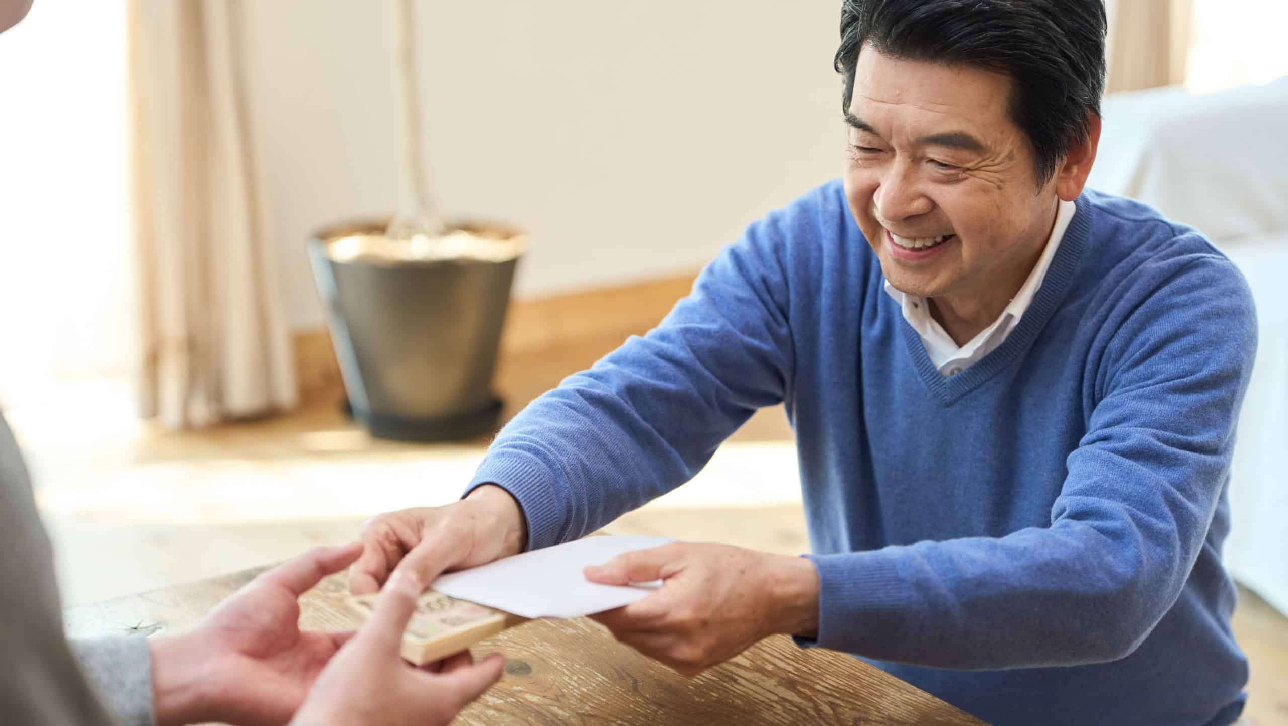 Senior Asian man handing over money