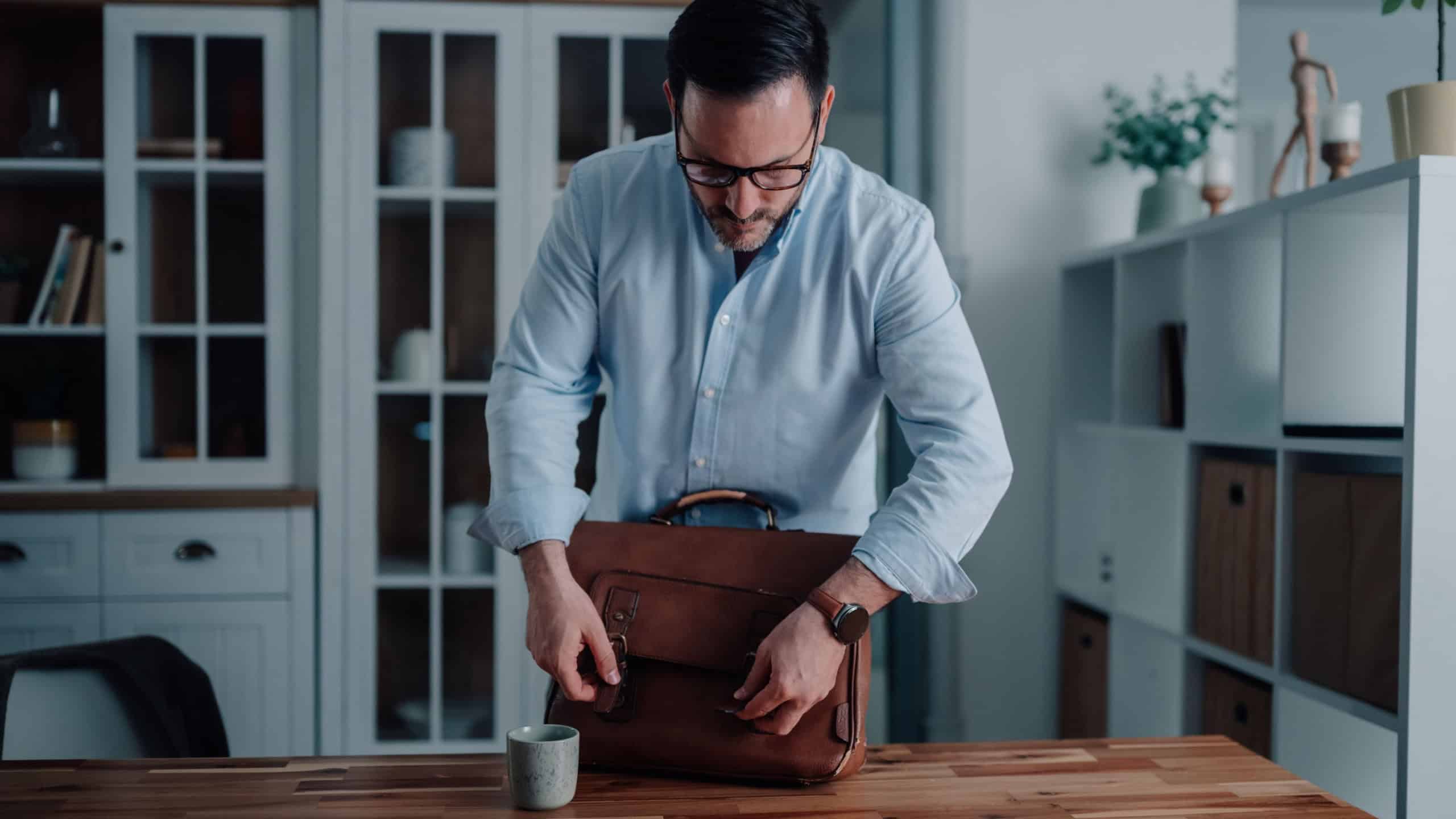 Professional man preparing a briefcase in a modern office environment.