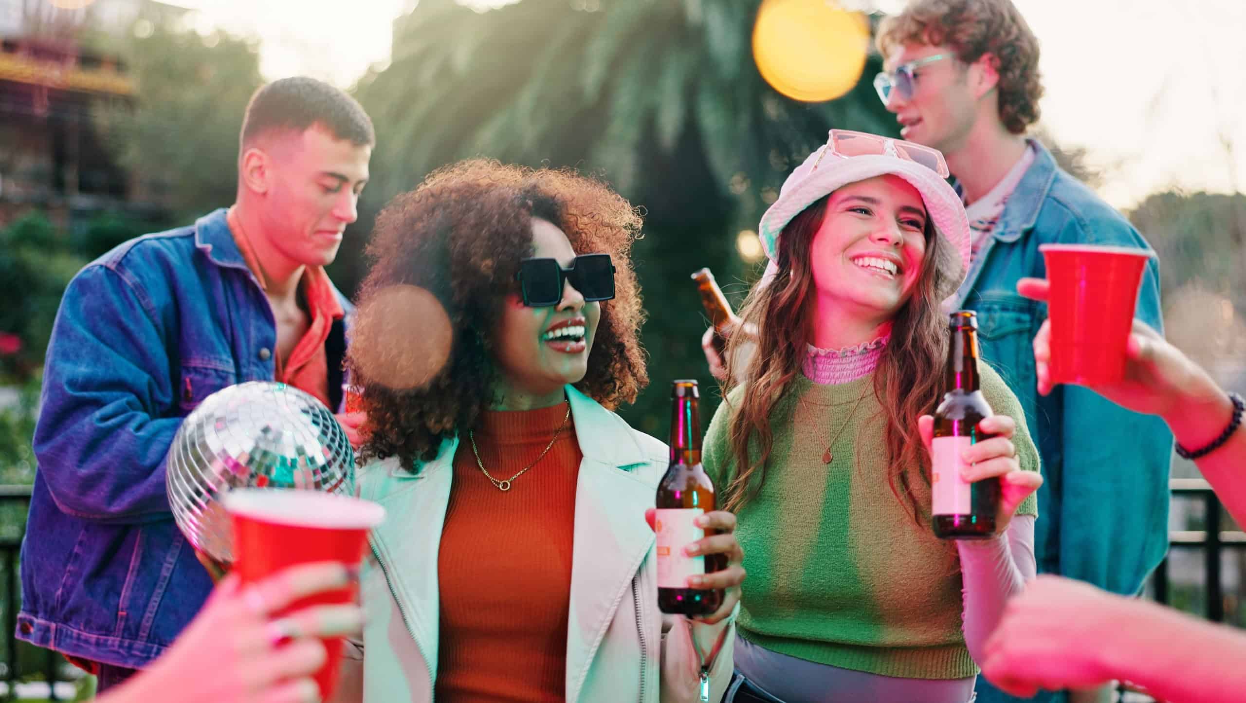 Dance, drink and reunion with friends outdoor together for bonding, celebration or social gathering. Alcohol, fun and party with group of people in backyard of home for energy, holiday or weekend