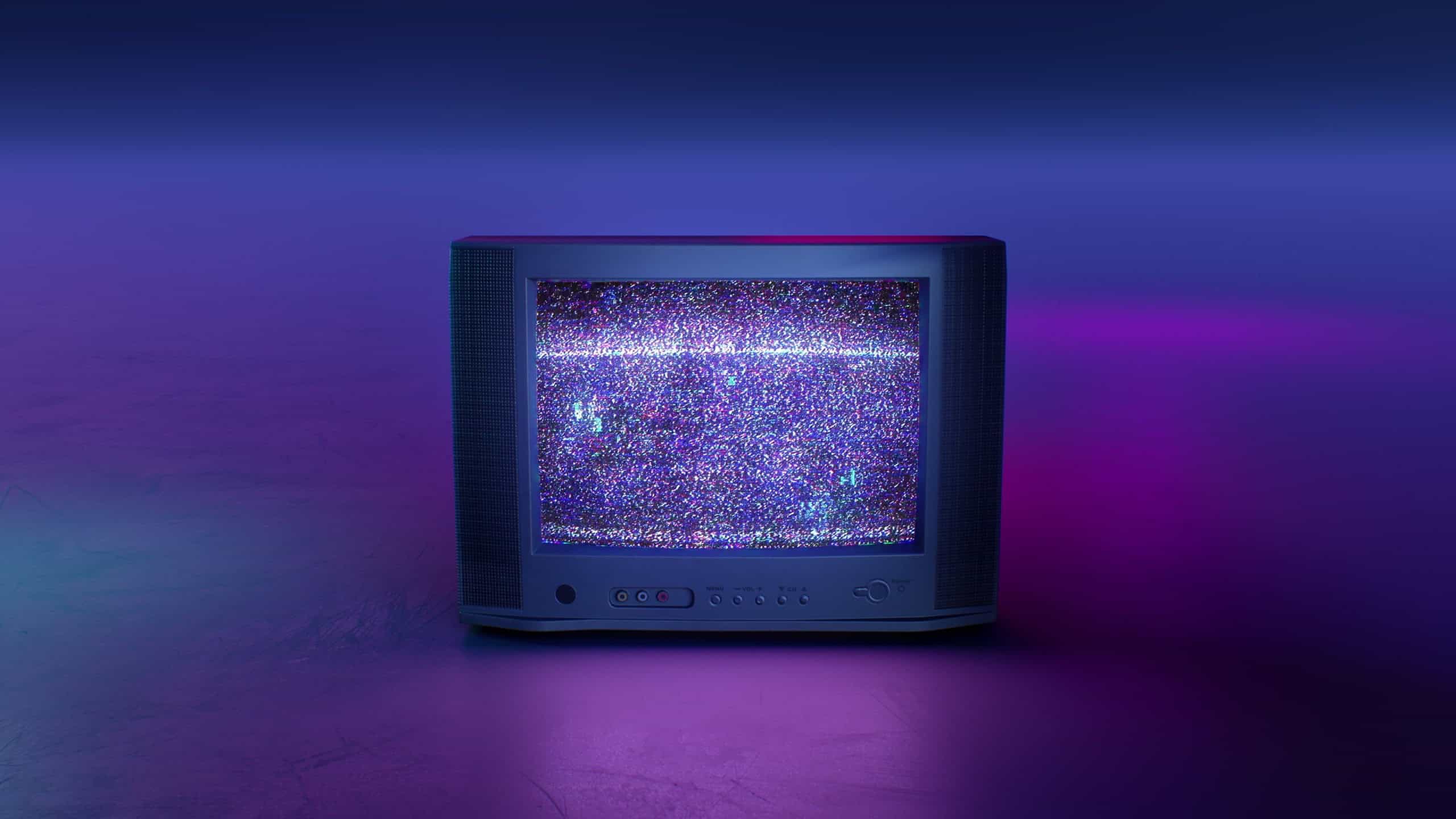 Retro Style Old TV Set with TV static on screen. Vintage 80s analog television with grain and No signal white noise. Broken television. Purple Neon Background. For mock up VFX compositing.