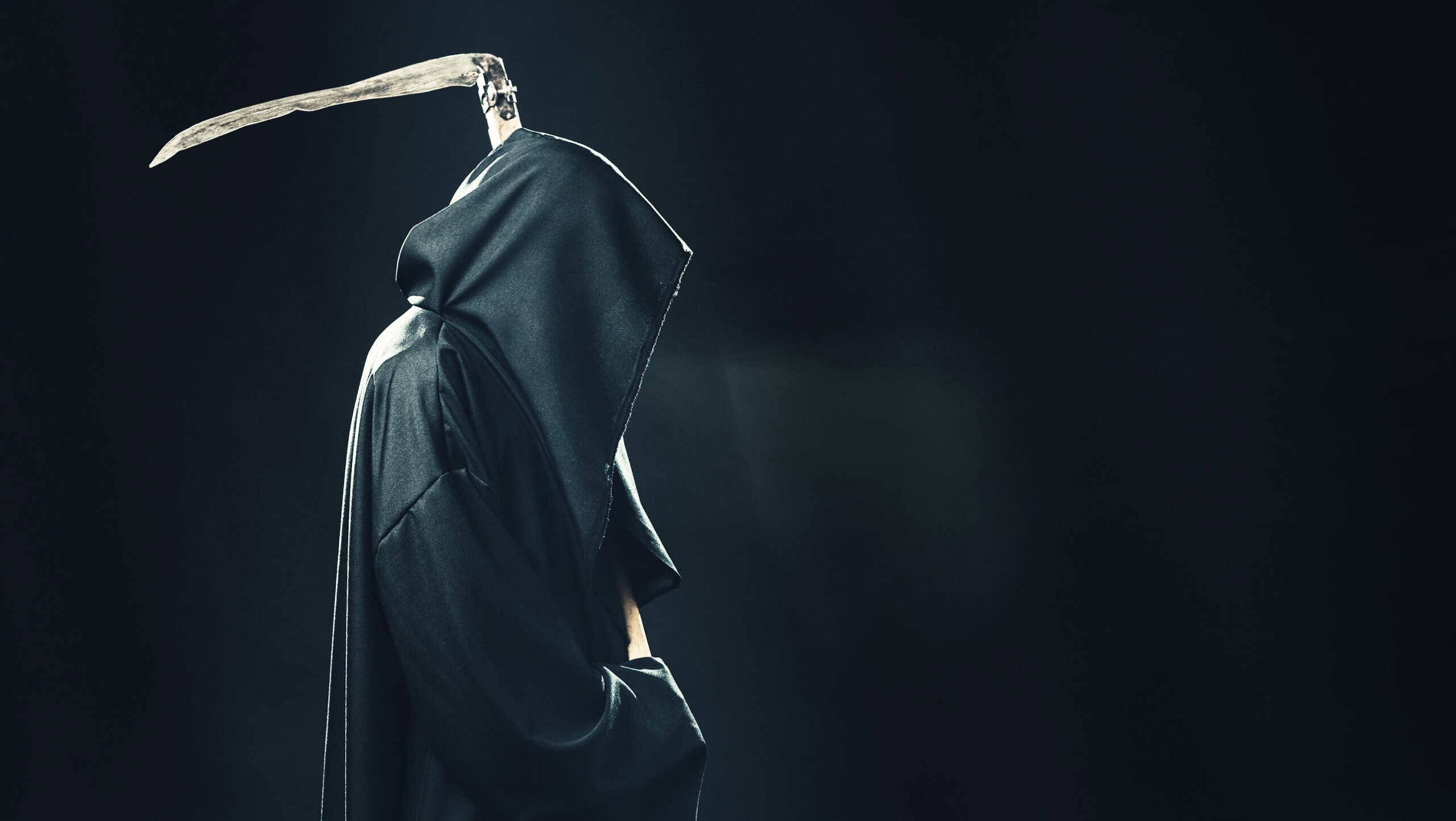 death with scythe standing in the fog at night