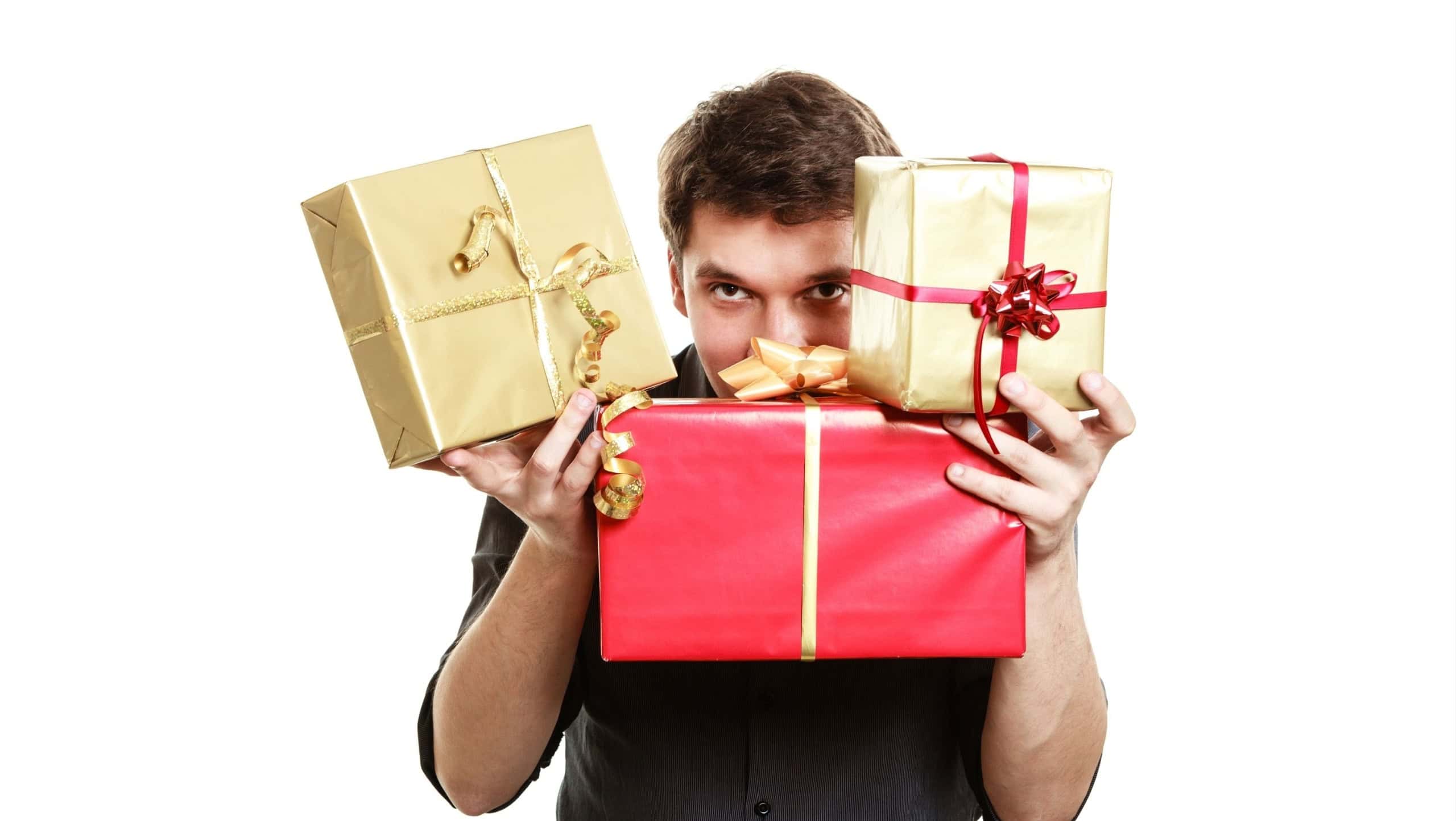 Holiday and special occasion. Young handsome man giving a lot of presents gifts boxes isolated on white. Surprise. Studio shot.