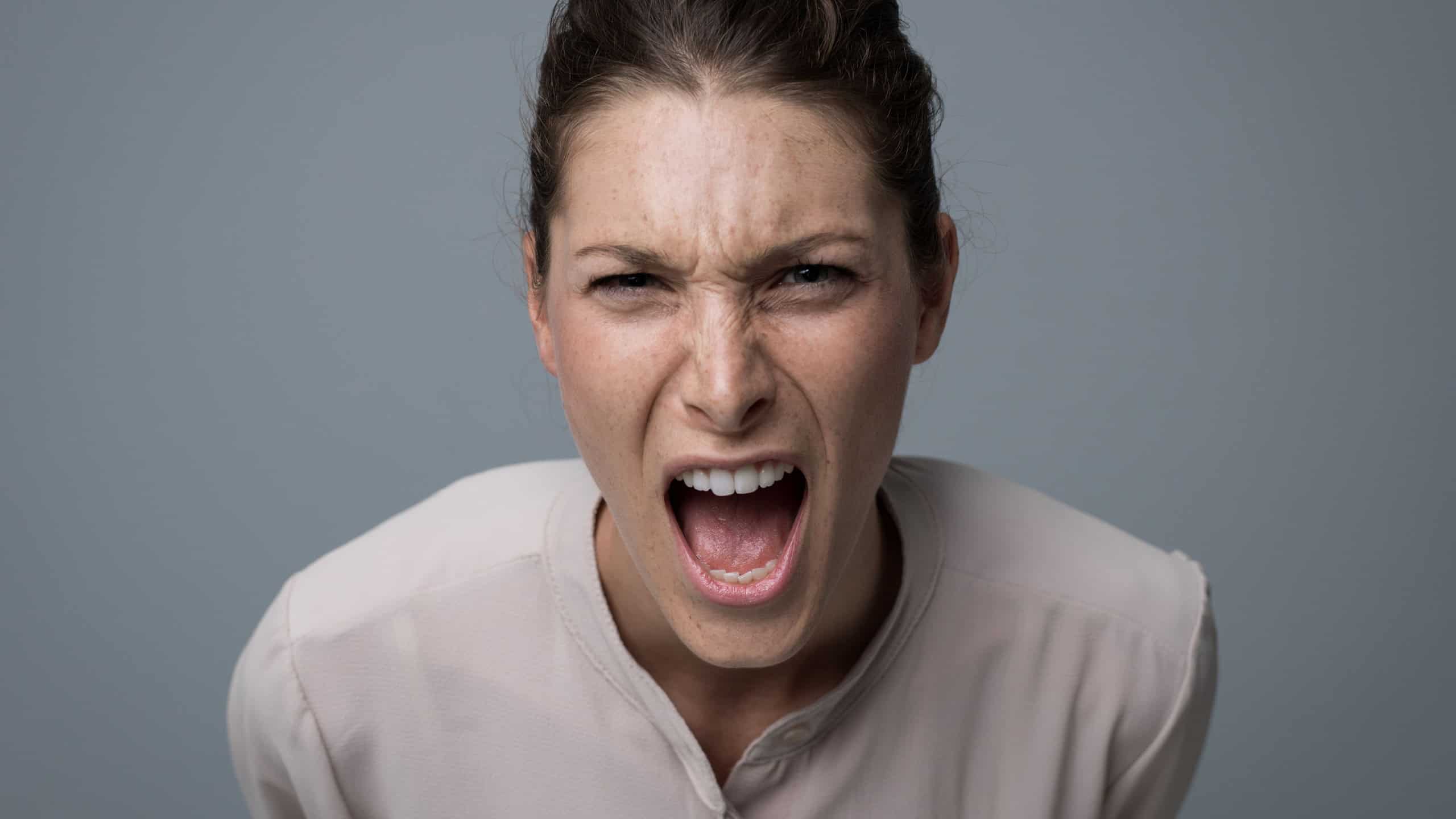 Aggressive angry woman yelling at camera, stress and negative feelings concept
