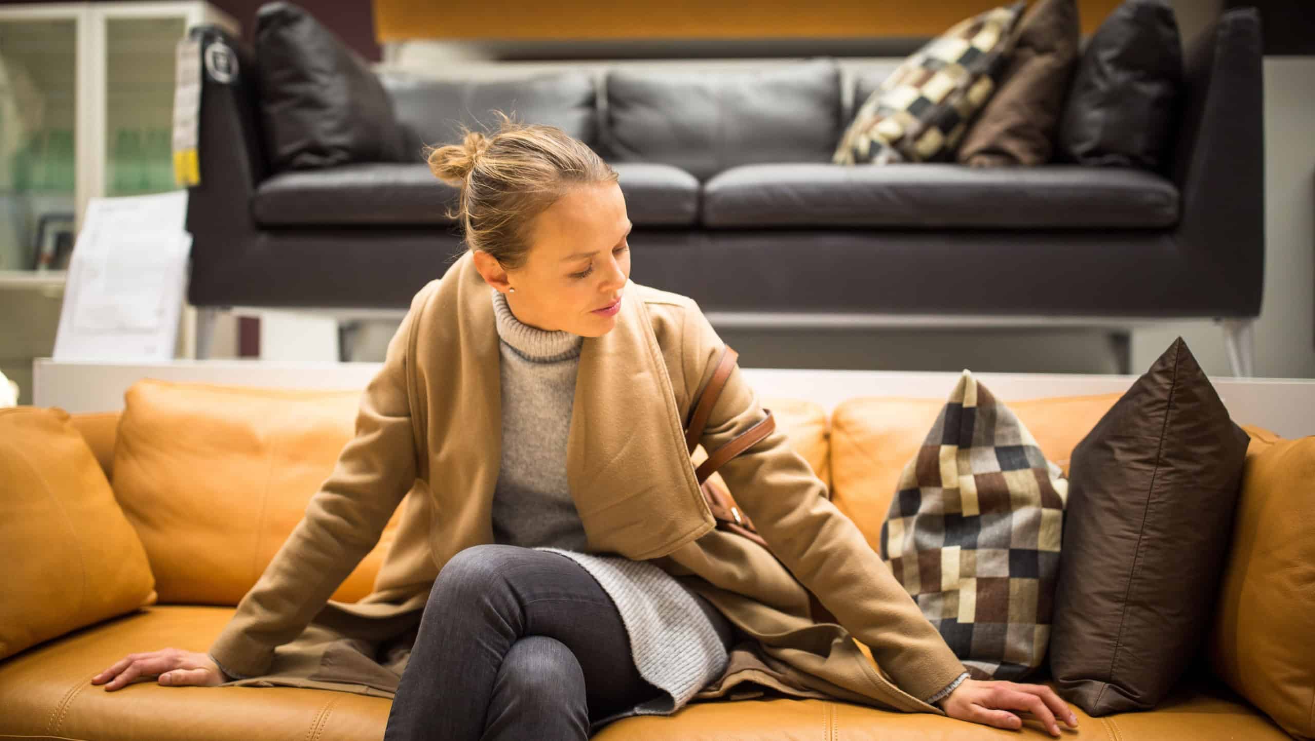 Pretty, young woman choosing the right furniture for her apartme