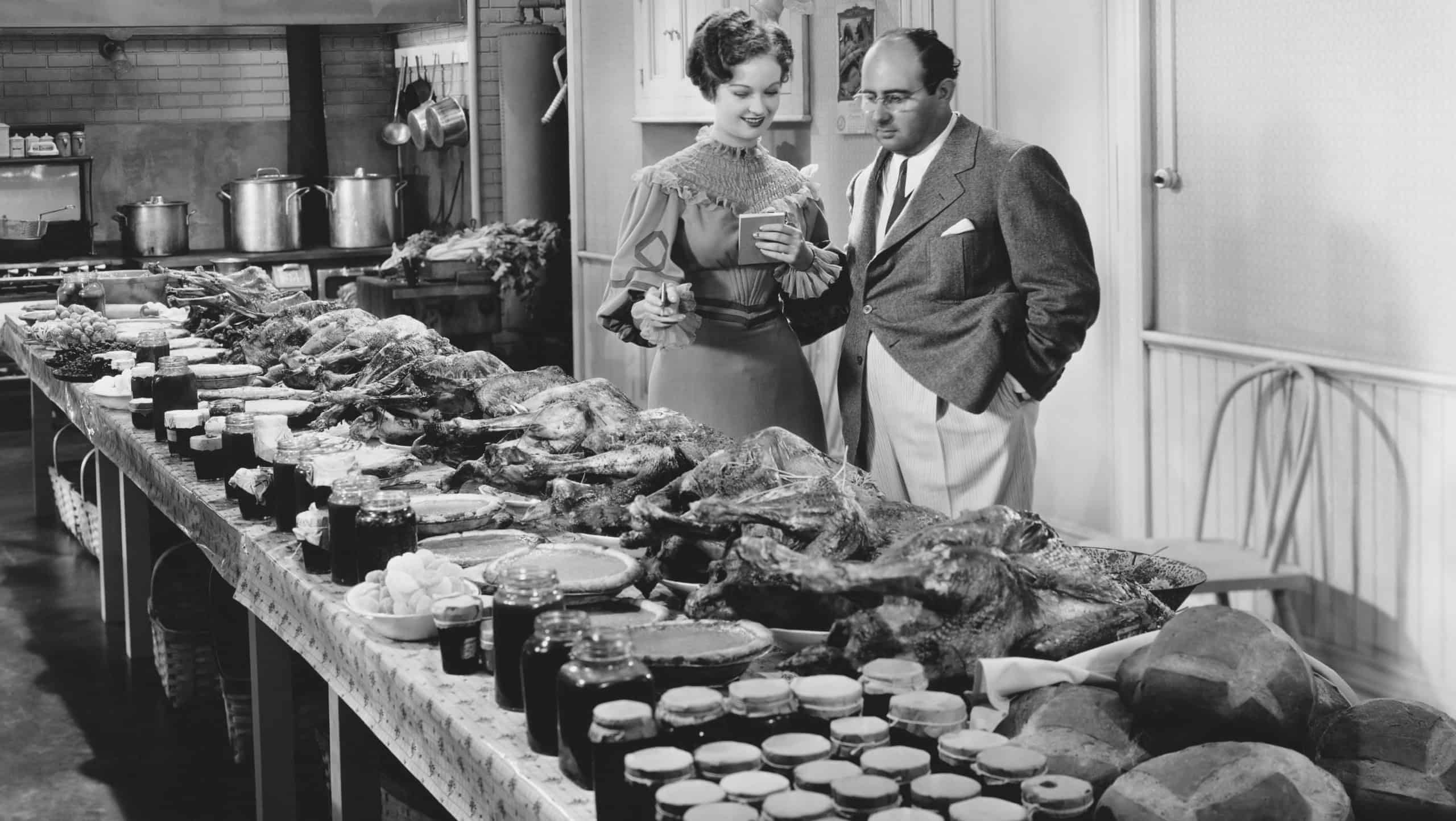 Couple with table covered in food for holiday meal