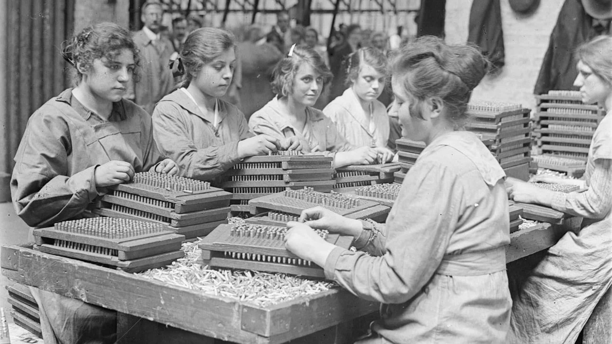 Women workers place bullets into trays during WWI