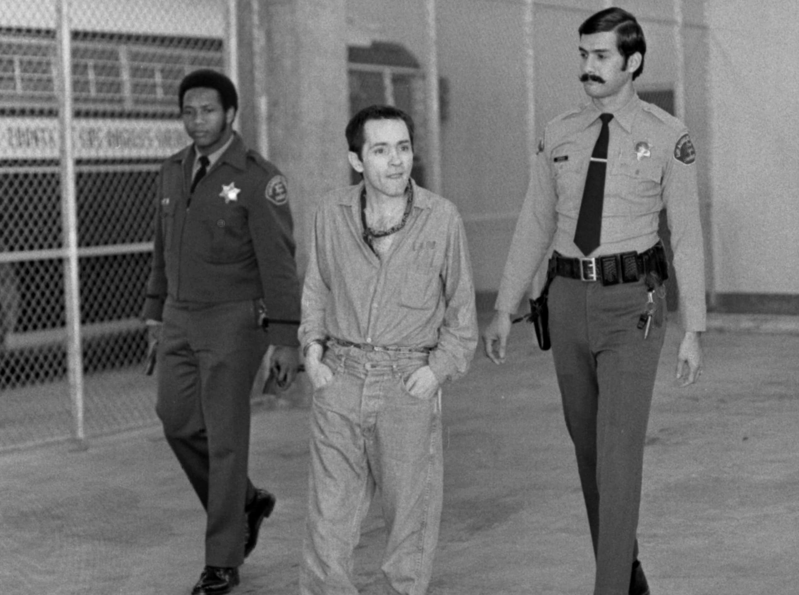 Charles Manson, escorted by two Los Angeles Sheriffs, 1973