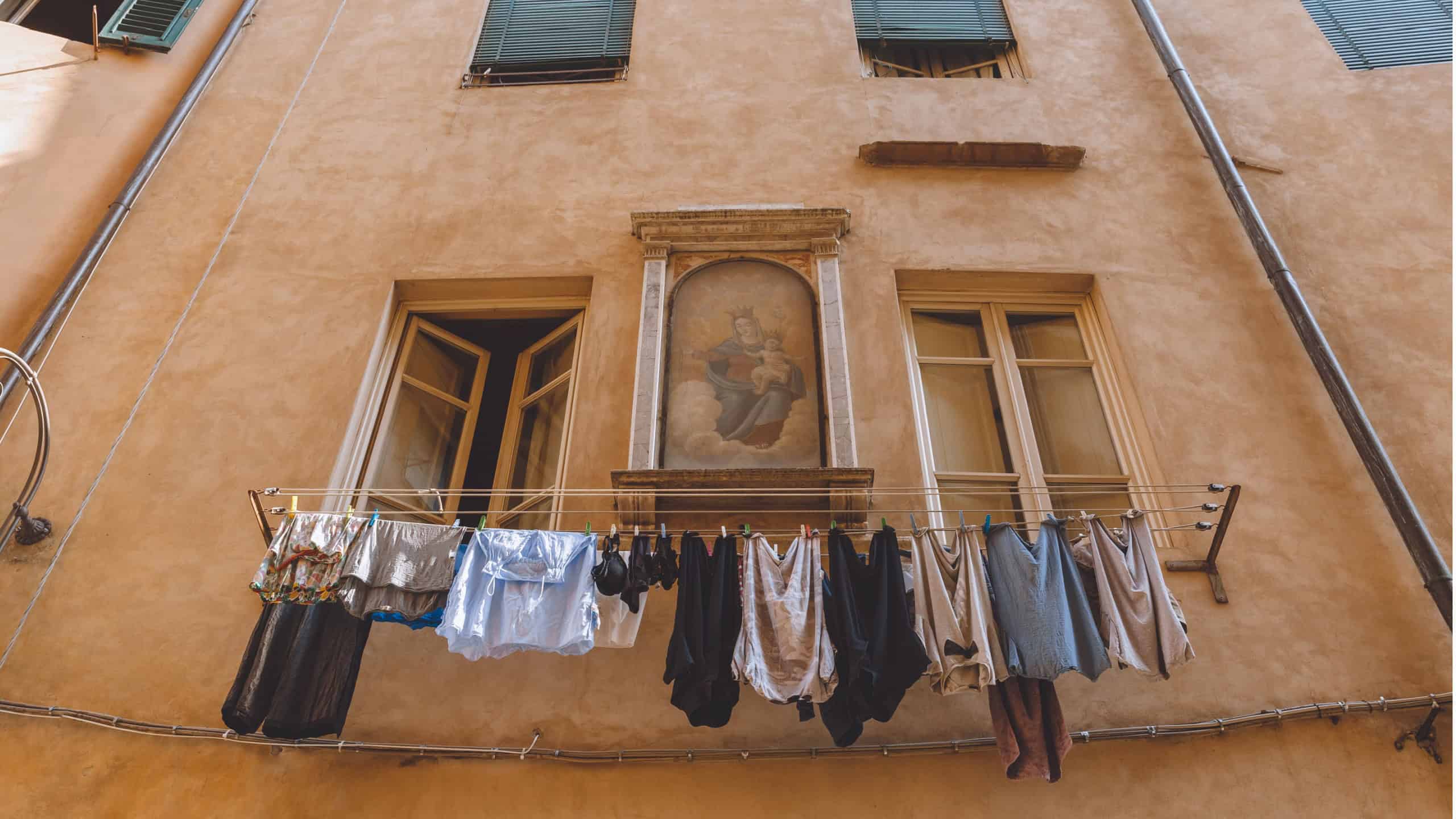laundry hanging outside buildings with icon on wall in Pisa, Italy