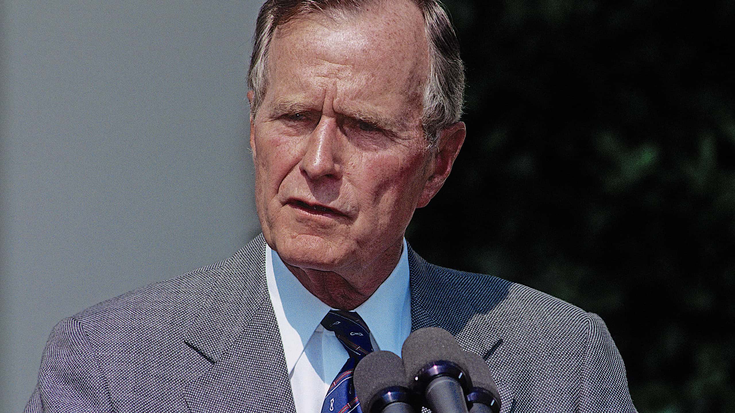 President George H.W. Bush talks with and answers reporters questions during a press conference in the Rose Garden of the White House
