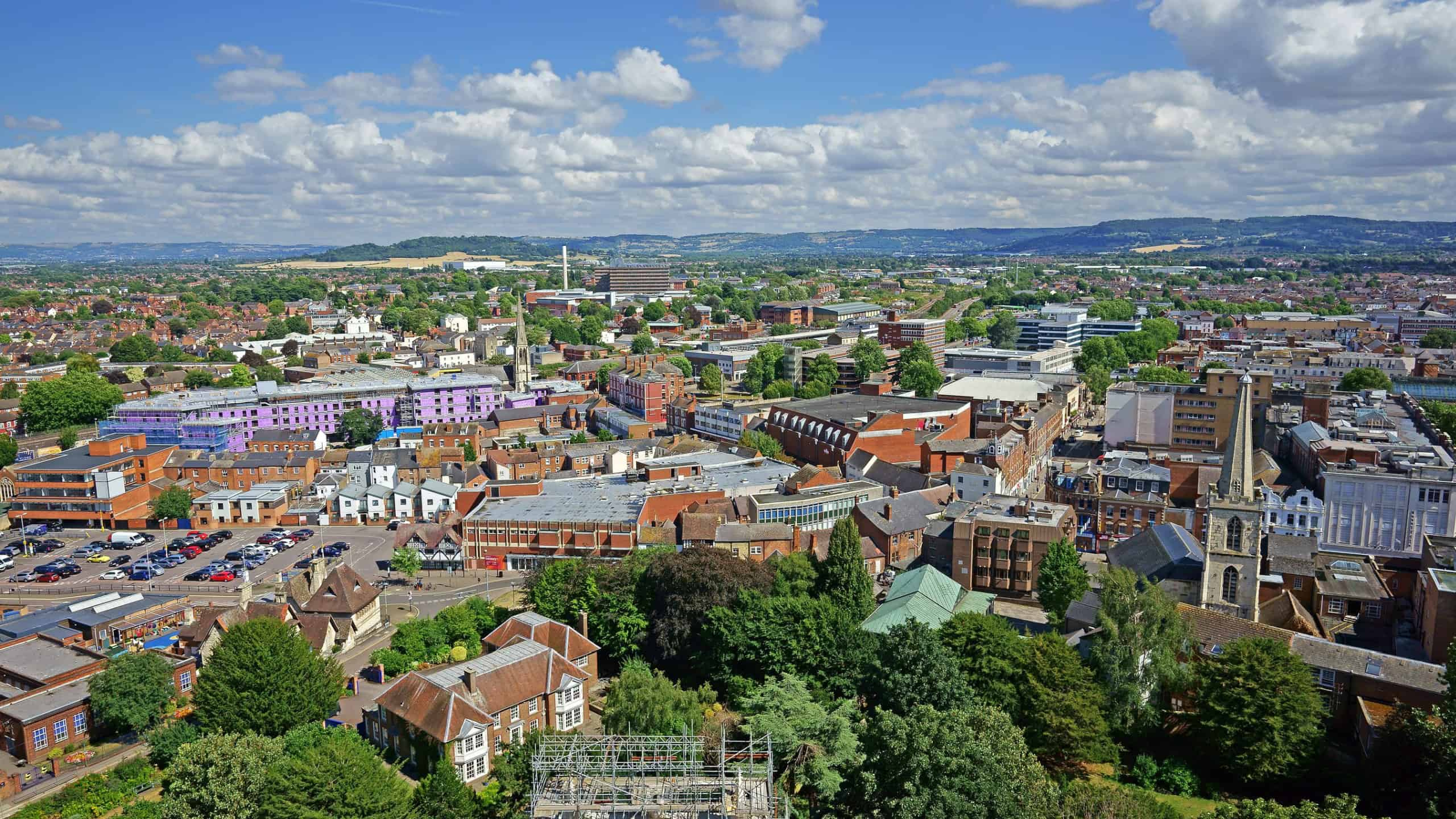 An aerial view of Gloucester City looking East towards Cheltenham, Leckhampton, Presbury and Cleeve Common, St John's Church can be seen in the midground, Gloucestershire, UK