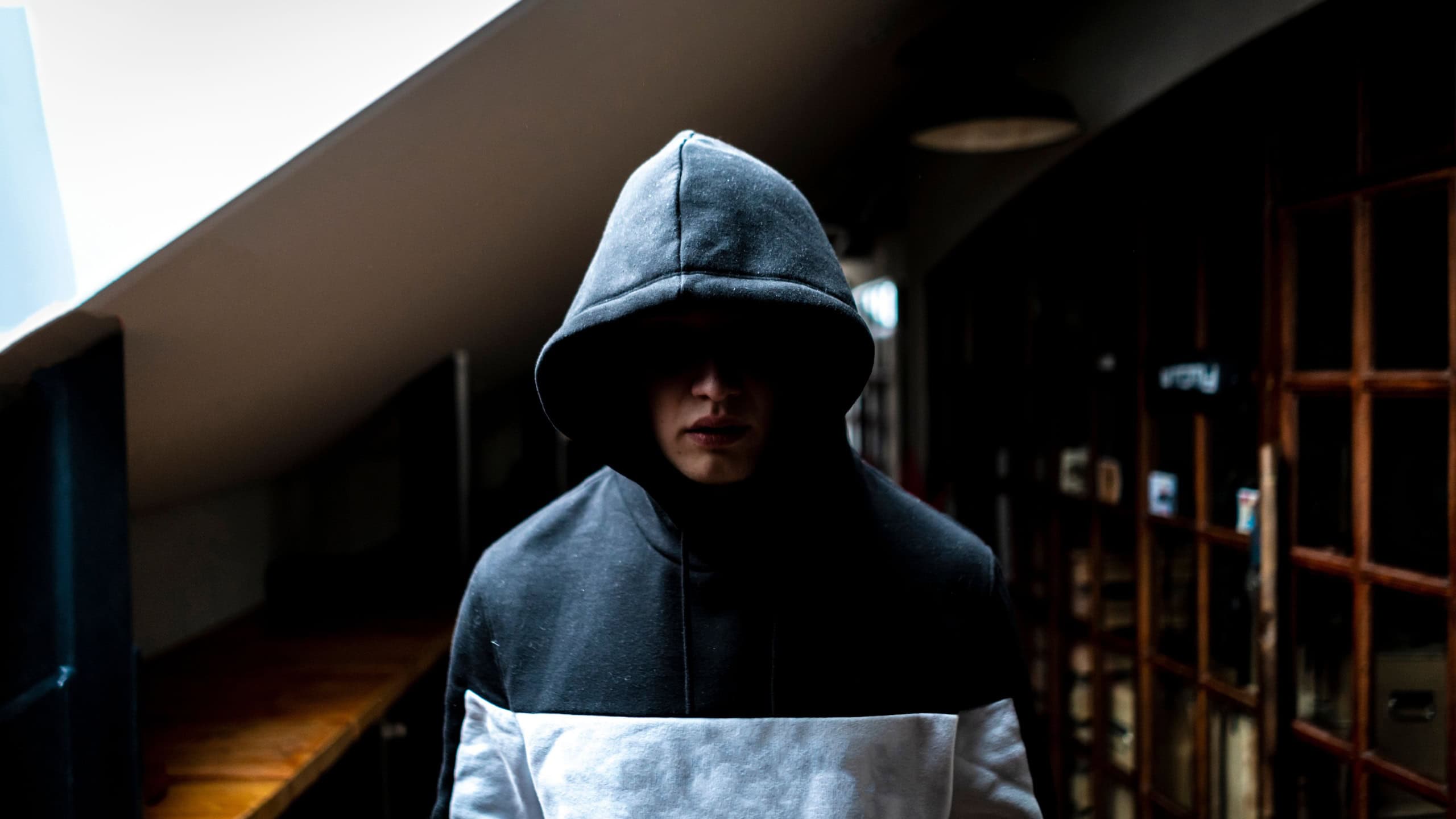 Anonymous man in the dark hood standing in the mysterious pose