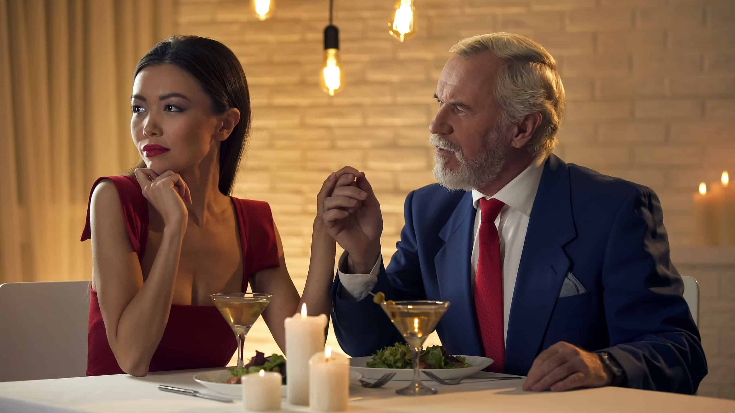 Young mistress ignoring elderly man during date, narcissist female in restaurant