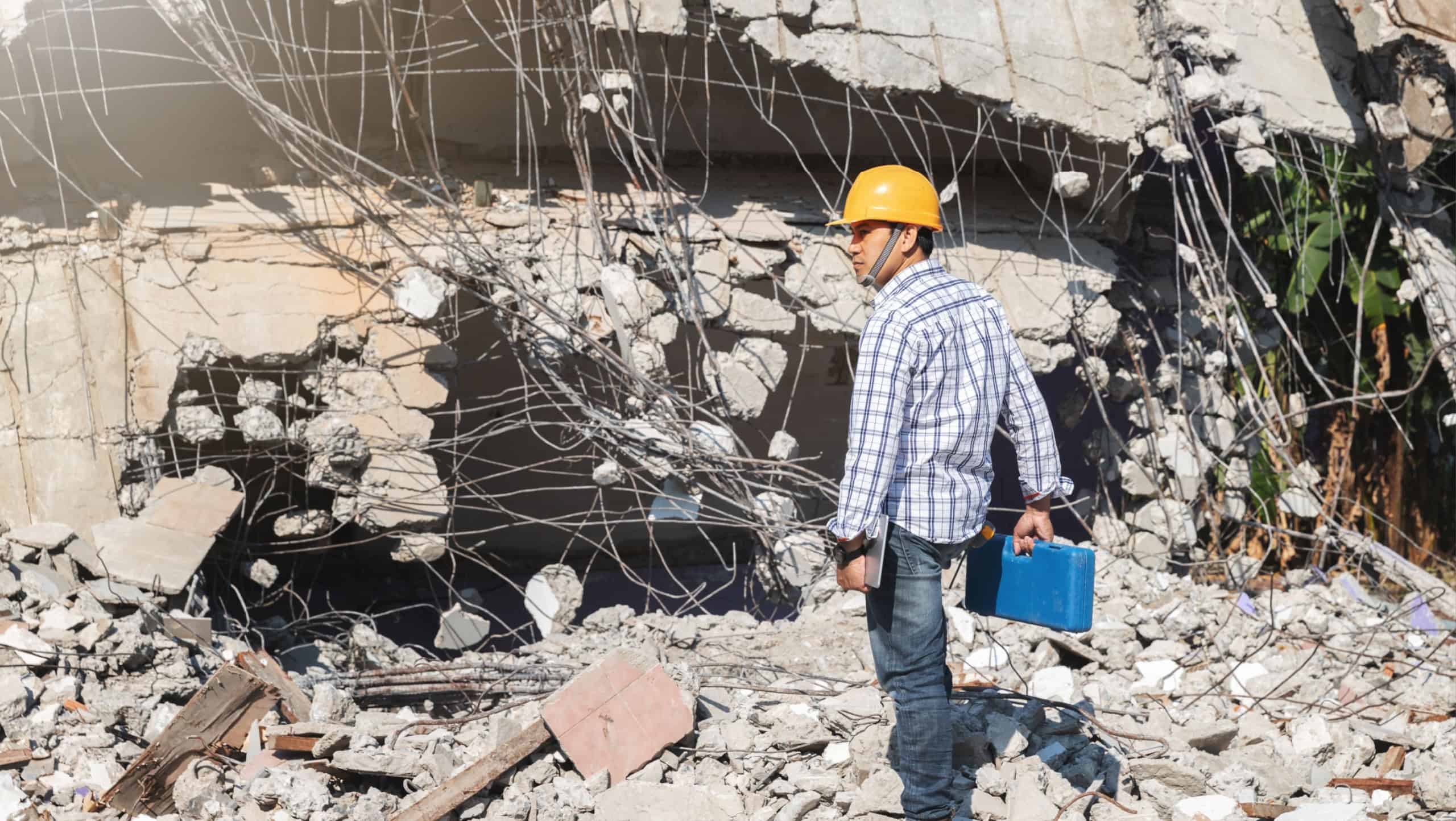 Engineer or contractor holding tool box in destruction demolishing building.