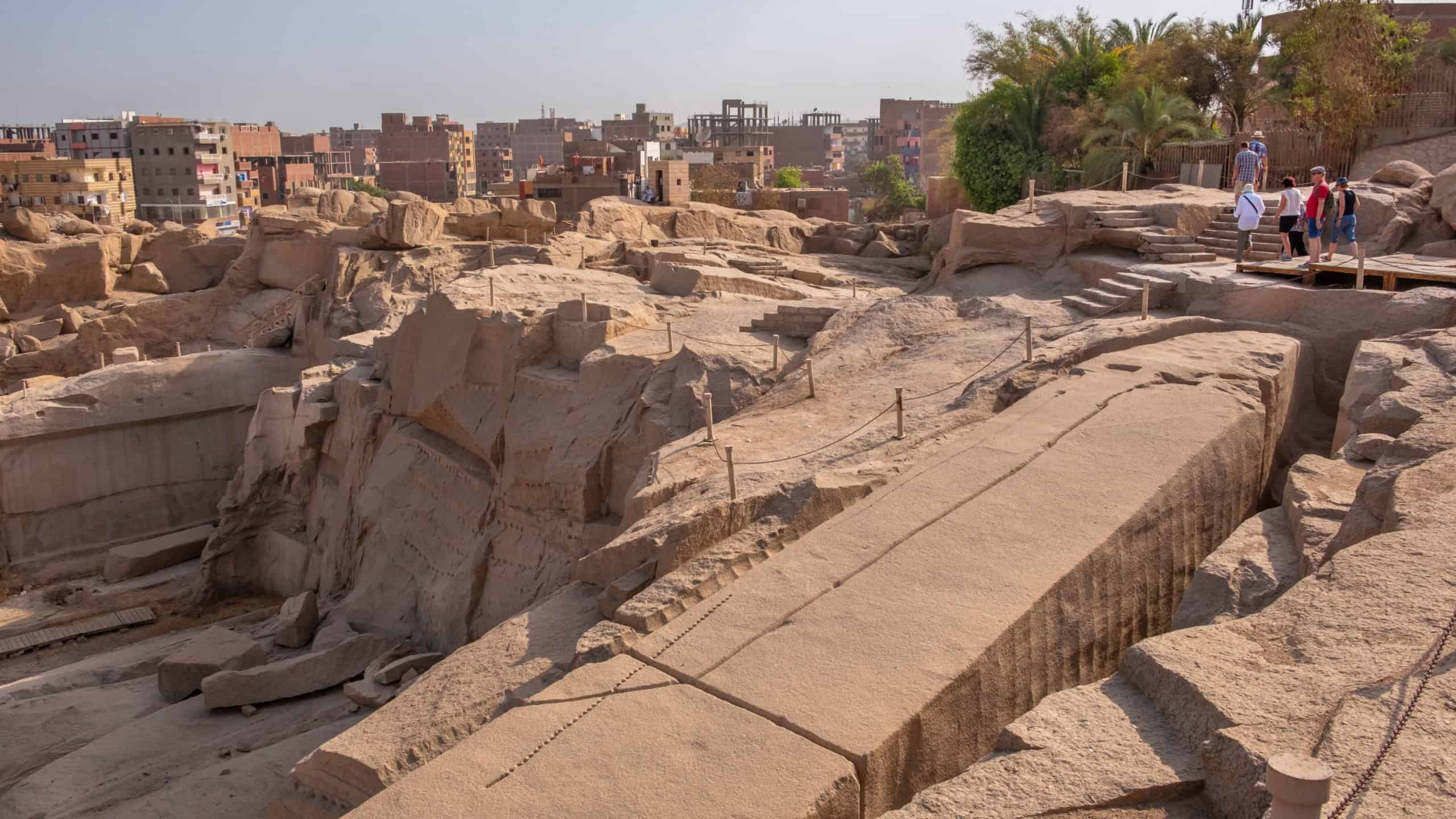ASWAN, EGYPT - JUNE 4, 2019: Tourists admiring the unfinished obelisk in a quarry at Aswan