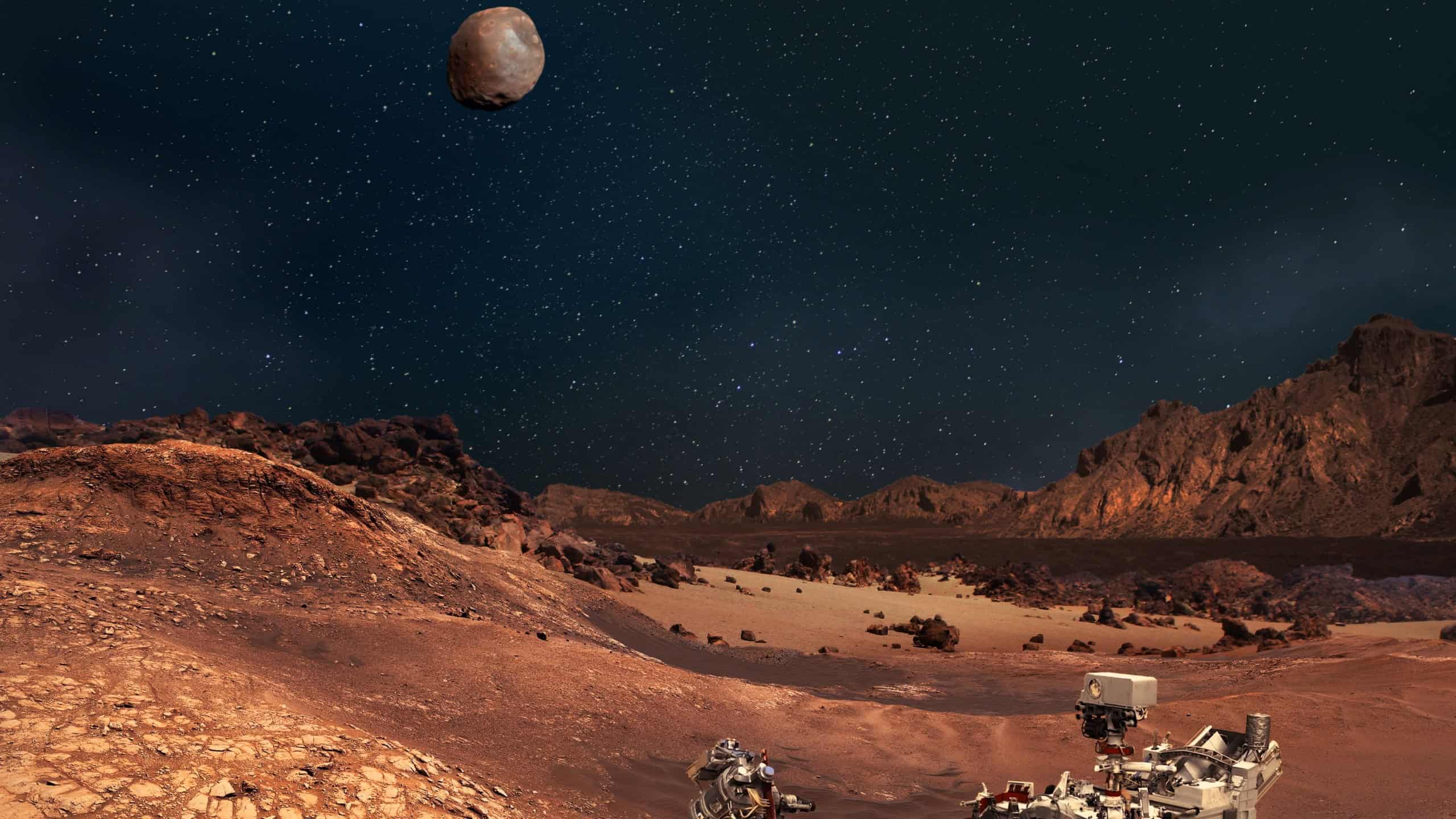 Perseverance rover in the Planet Mars rocky landscape. Moons Phobos and Deimos on the sky. Some elements furnished by NASA.