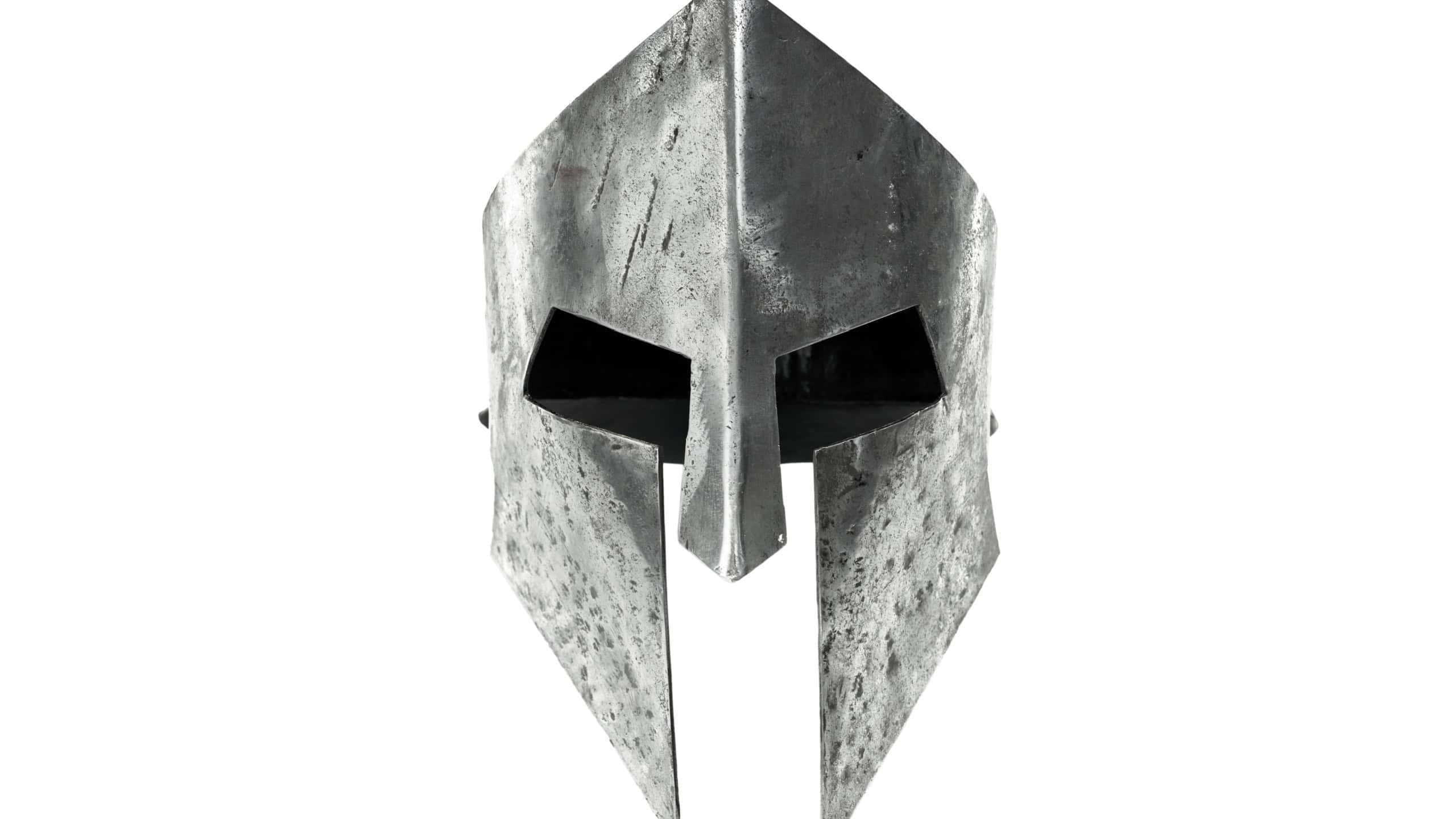 Front view of ancient iron spartan helmet isolated on white studio background. Medieval armor, archeological souvenir from past times, metal tough head protective clothes.