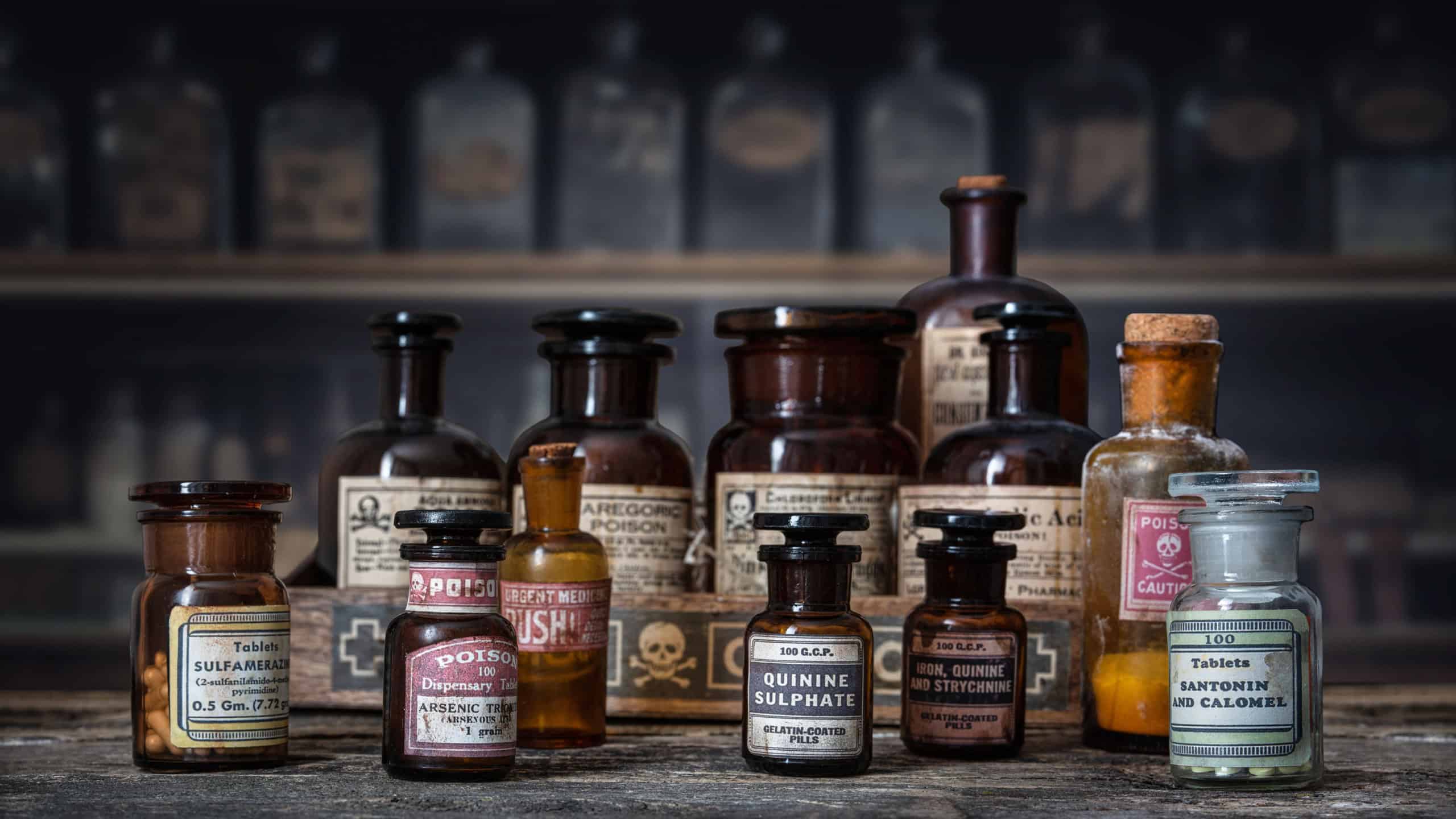 Bottles with drugs from old medical, chemical and pharmaceutical glass. Chemistry and pharmacy history concept background. Retro style. Chemical substances-sulfamerazin, arsenic trioxid etc.