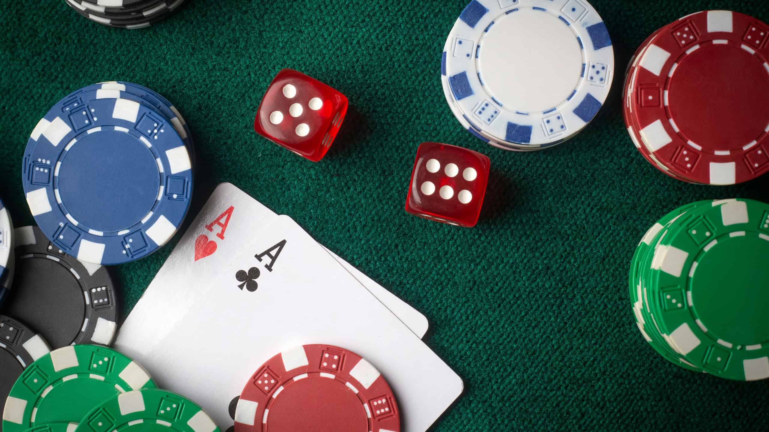 Playing cards, dice and poker chips from above on the green poker table