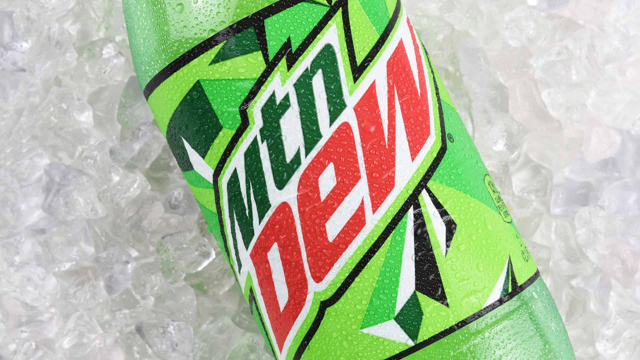 MTN Dew bottle Closeup on ice. Mountain Dew is a carbonated citrus soft drink produced and owned by PepsiCo.
