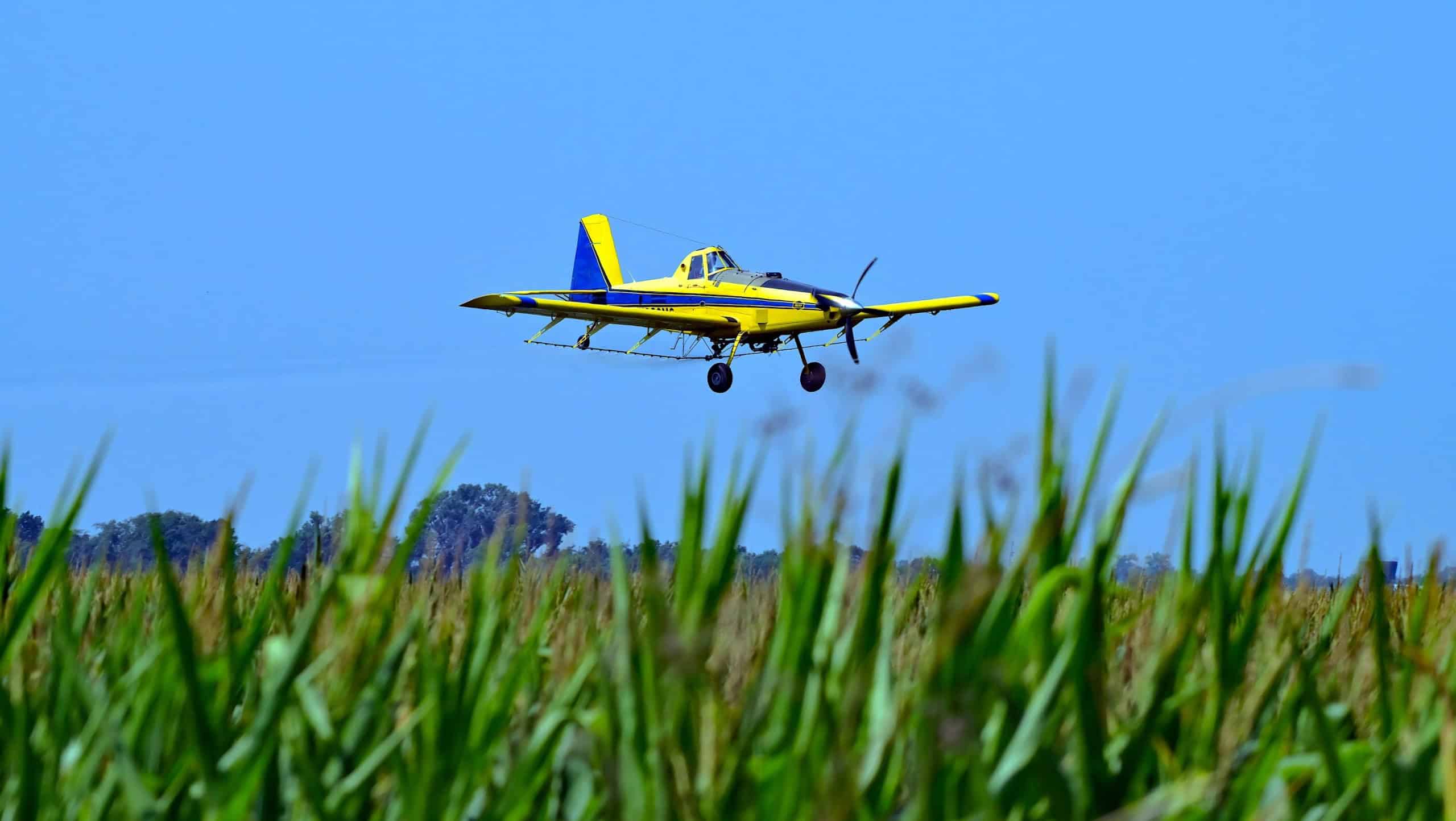 Americus, Kansas, July 30, 2021Air Tractor 502XP crop dusting airplane spraying some of the 500 gallons of its liquid insecticide payload over fields of corn and soybeans