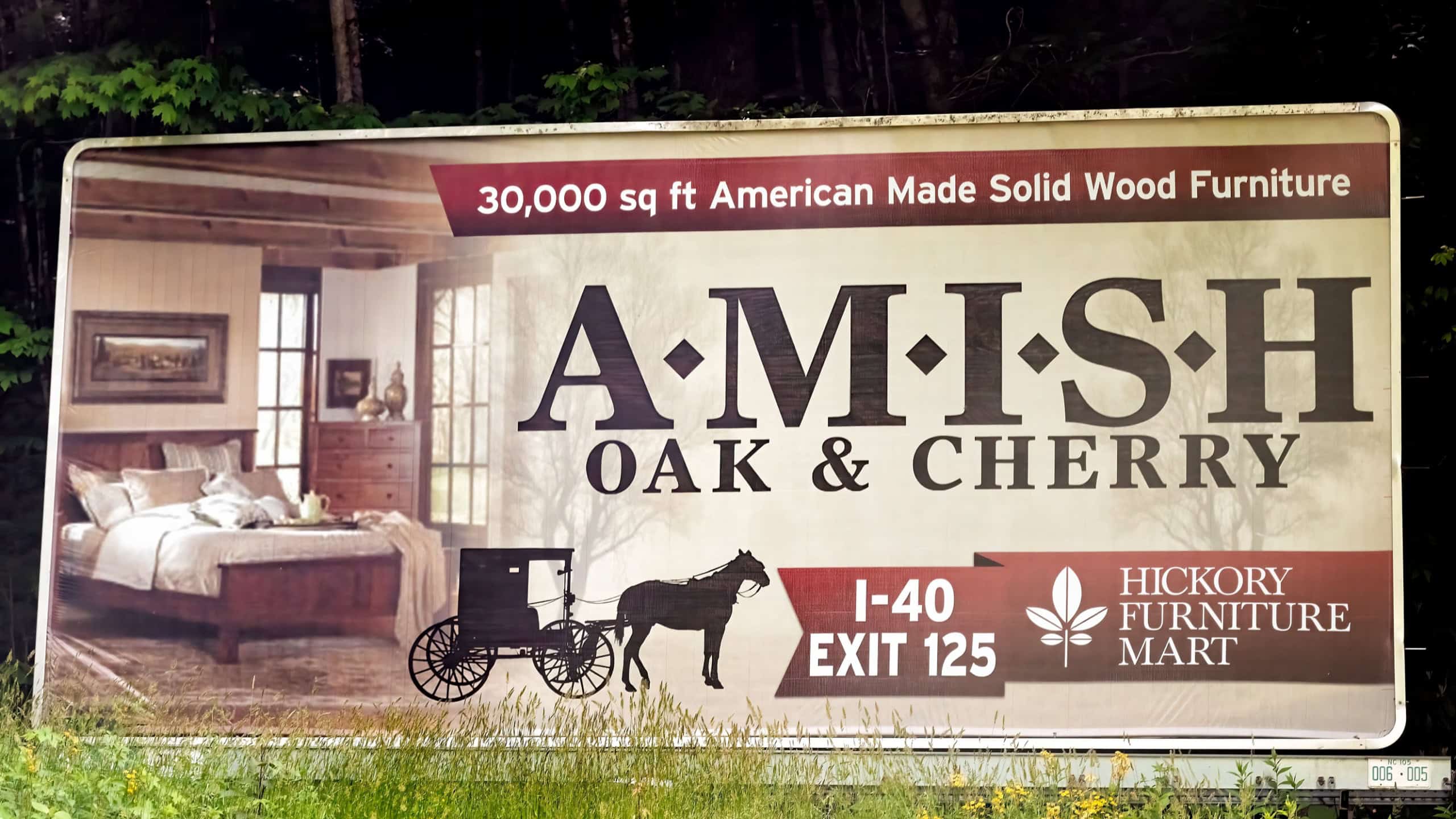 North Carolina city with road billboard sign for American made solid wood furniture of oak and cherry at Amish mart store shop