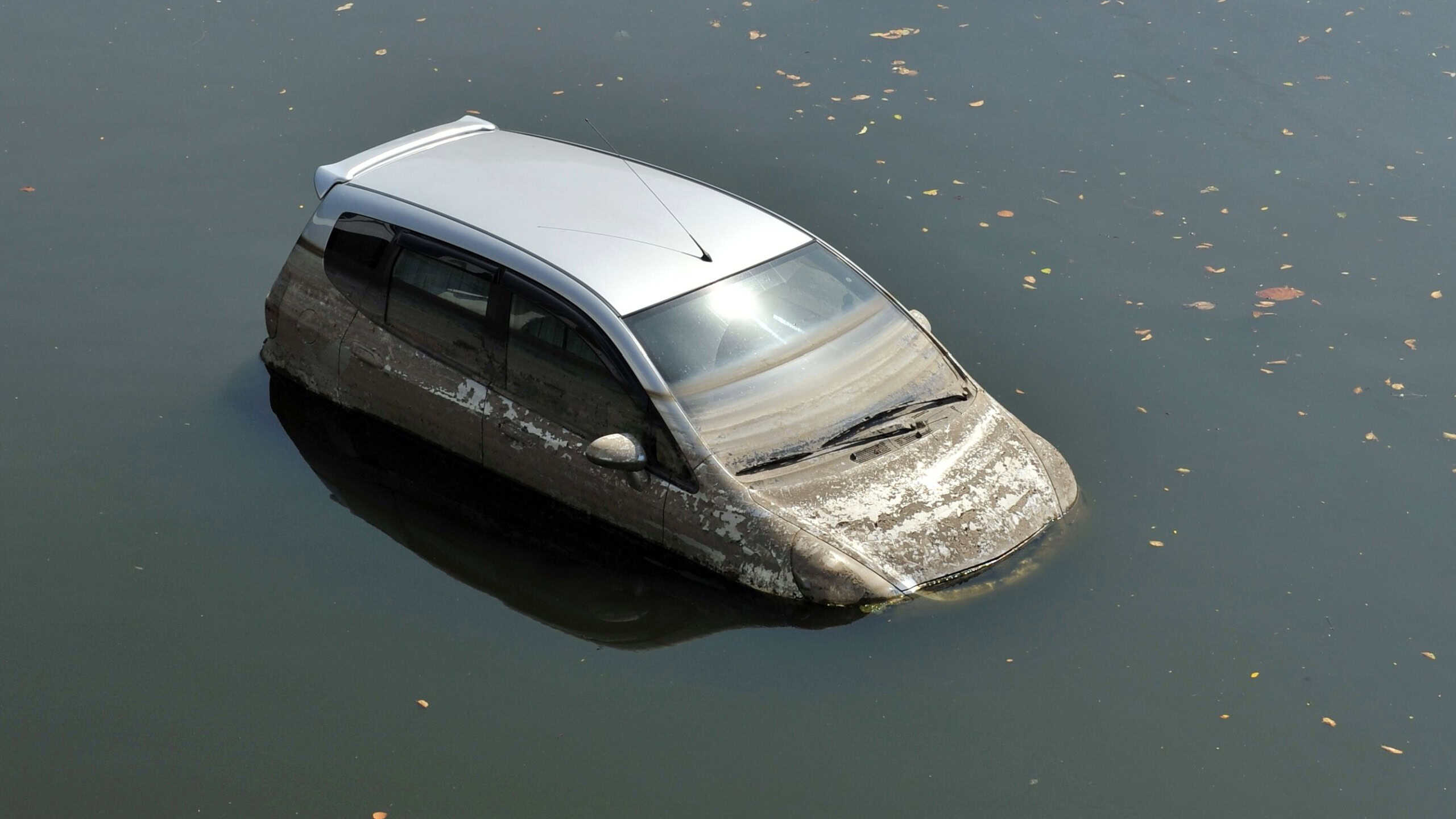 A Car Sits in a Flooded Car Park - Motor Vehicle Insurance Claim Themed Image
