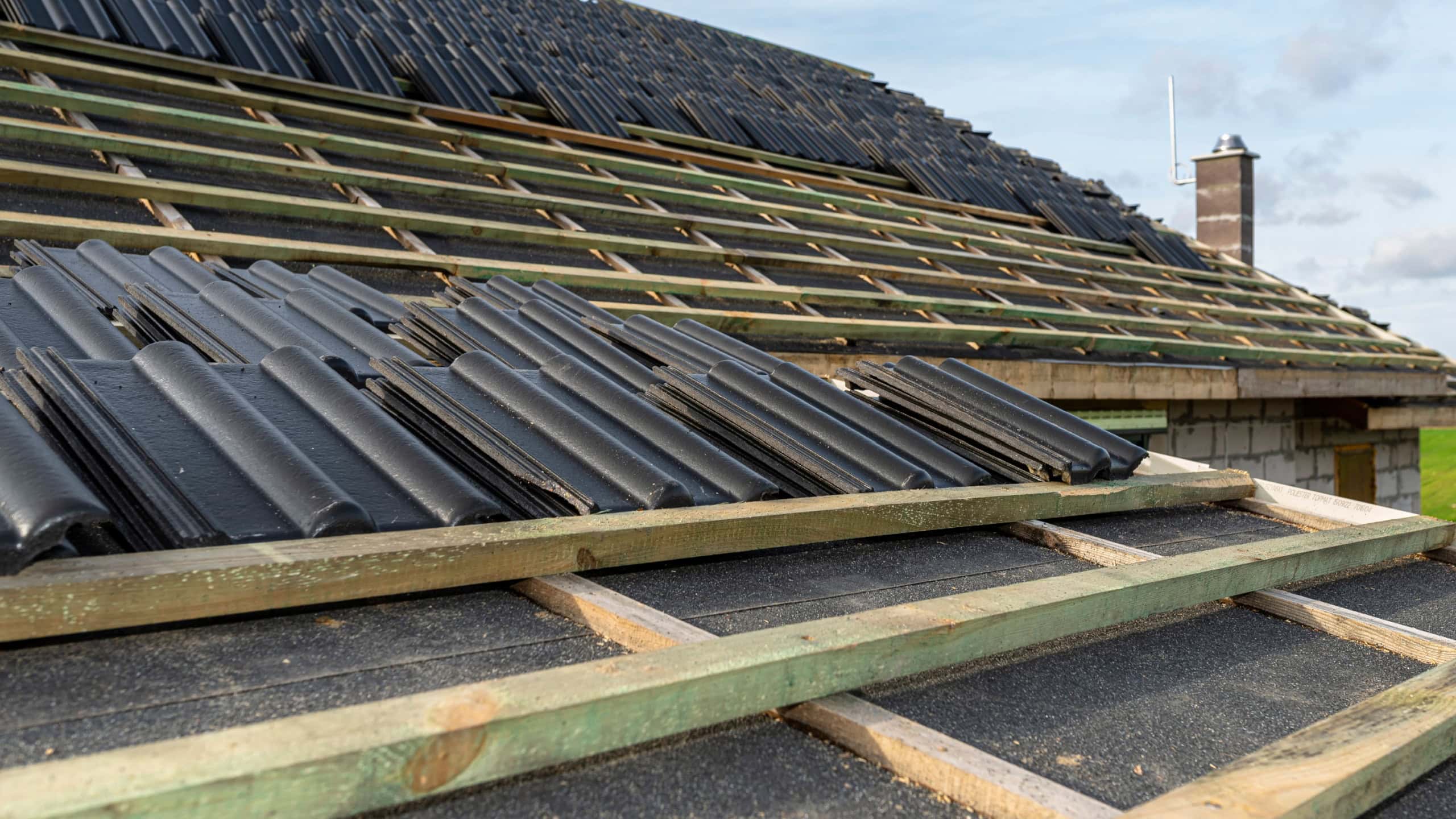 Roof ceramic tile arranged in packets on the roof on roof battens. Preparation for laying tiles on a boarded roof.