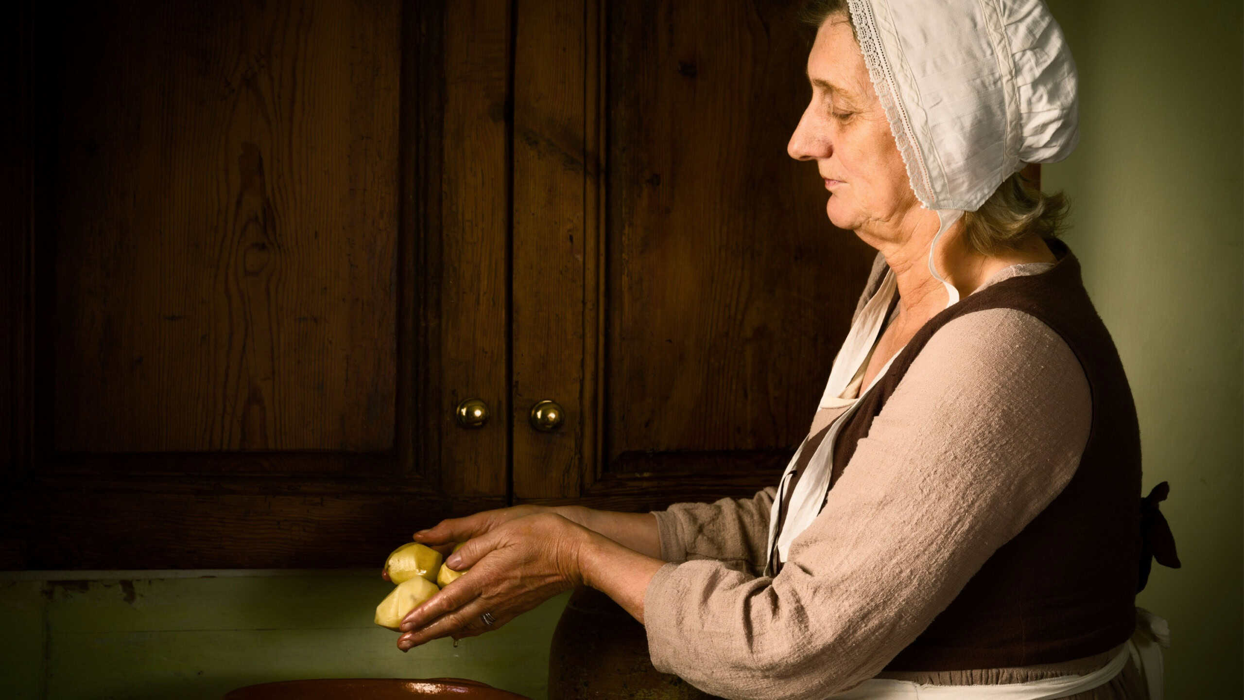 Old Master style Renaissance portrait of a woman preparing food in an antique kitchen