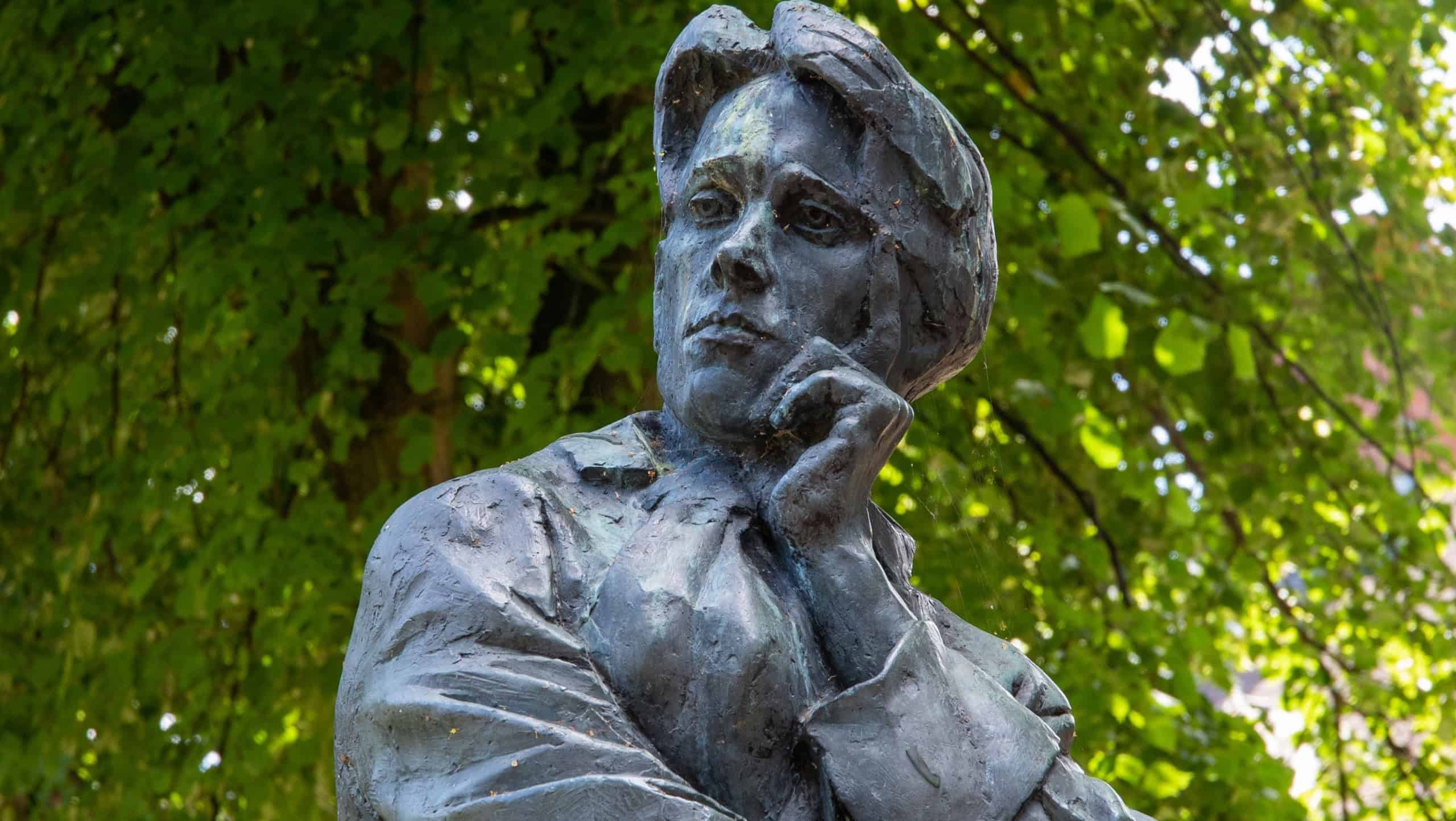 RUGBY, GB - Jul 09, 2022: A vertical shot of the statue of the famous WW1 poet Rupert Brooke in a park in Rugby, United Kingdom