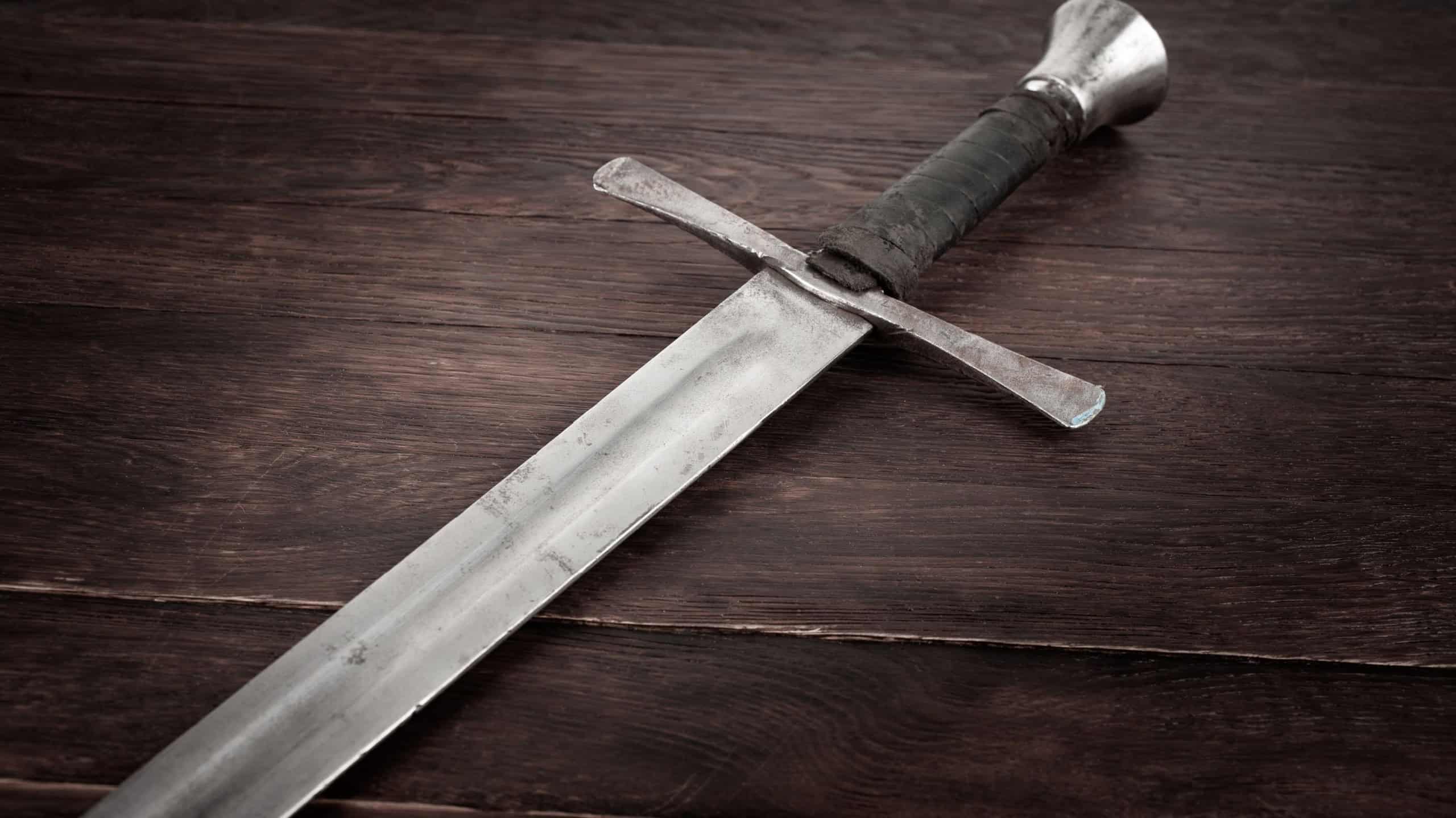 Medieval vintage sword on wooden background.