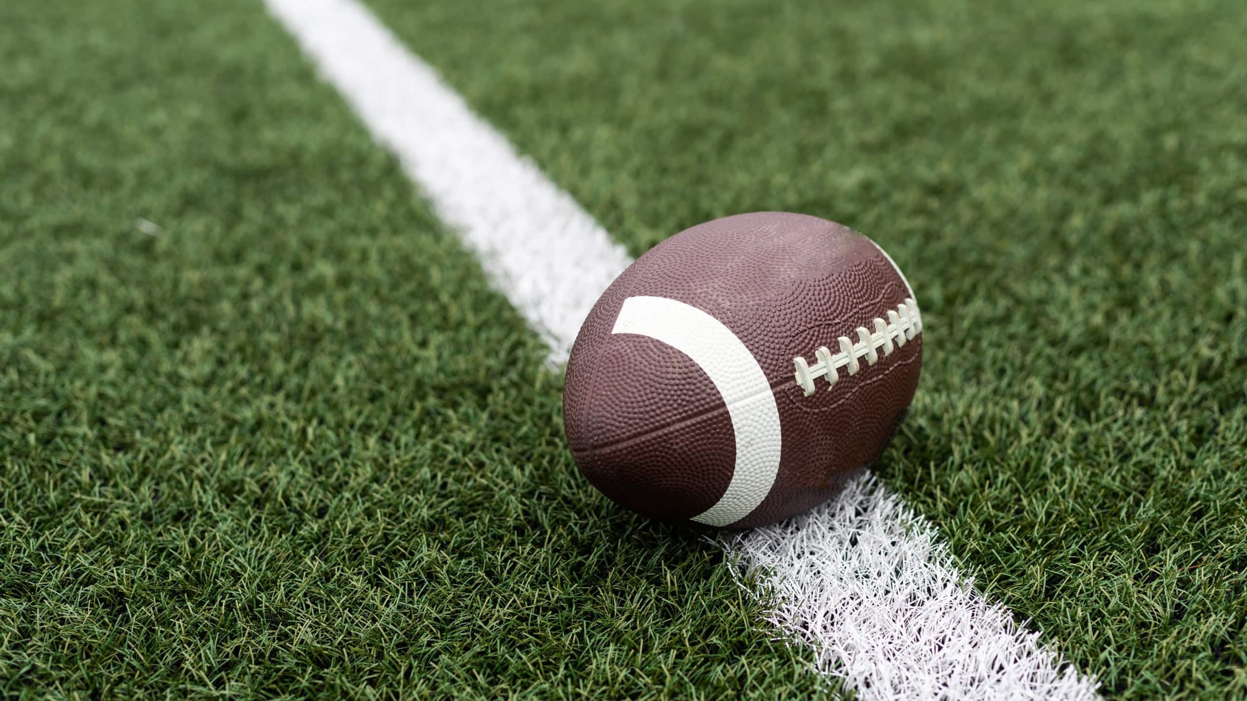 Football on hash marks of high school turf football field