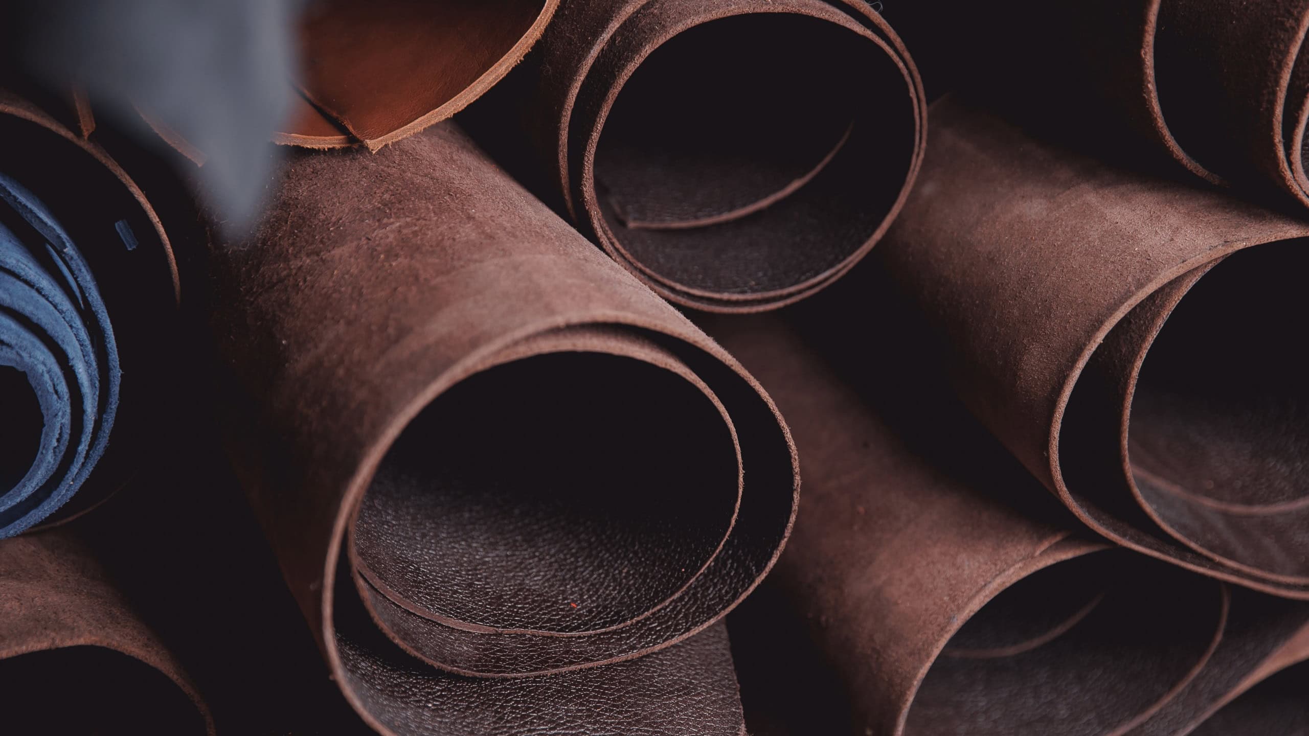 Banner of tailor, leather rolls of natural color in workshop. Materials for DIY handmade craft.
