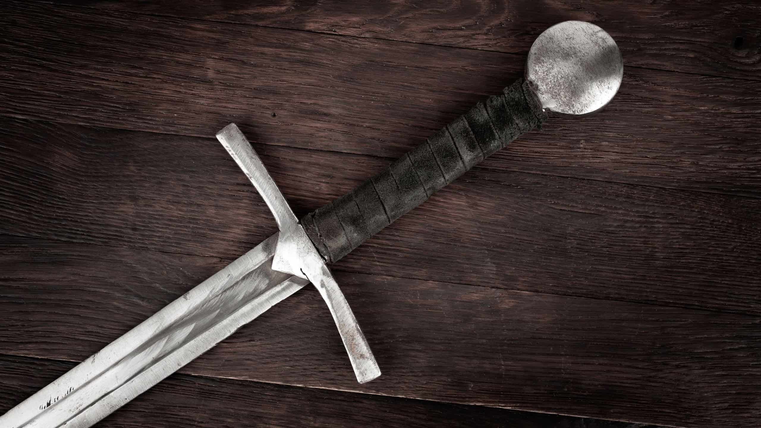 Medieval vintage sword on wooden background.