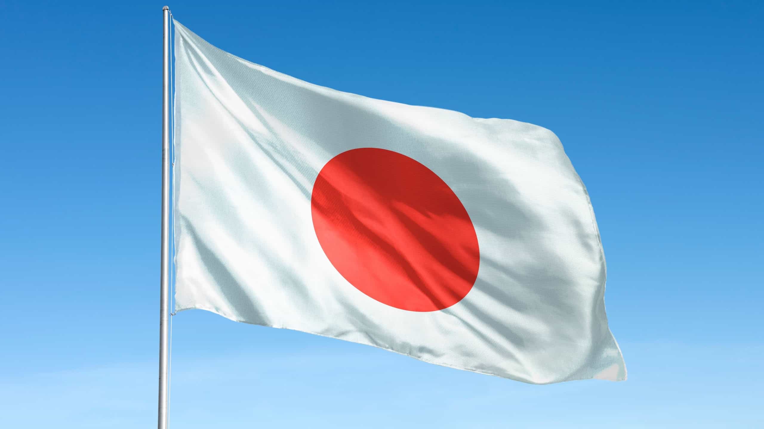 Waving Japan flag, national symbol, blue sky